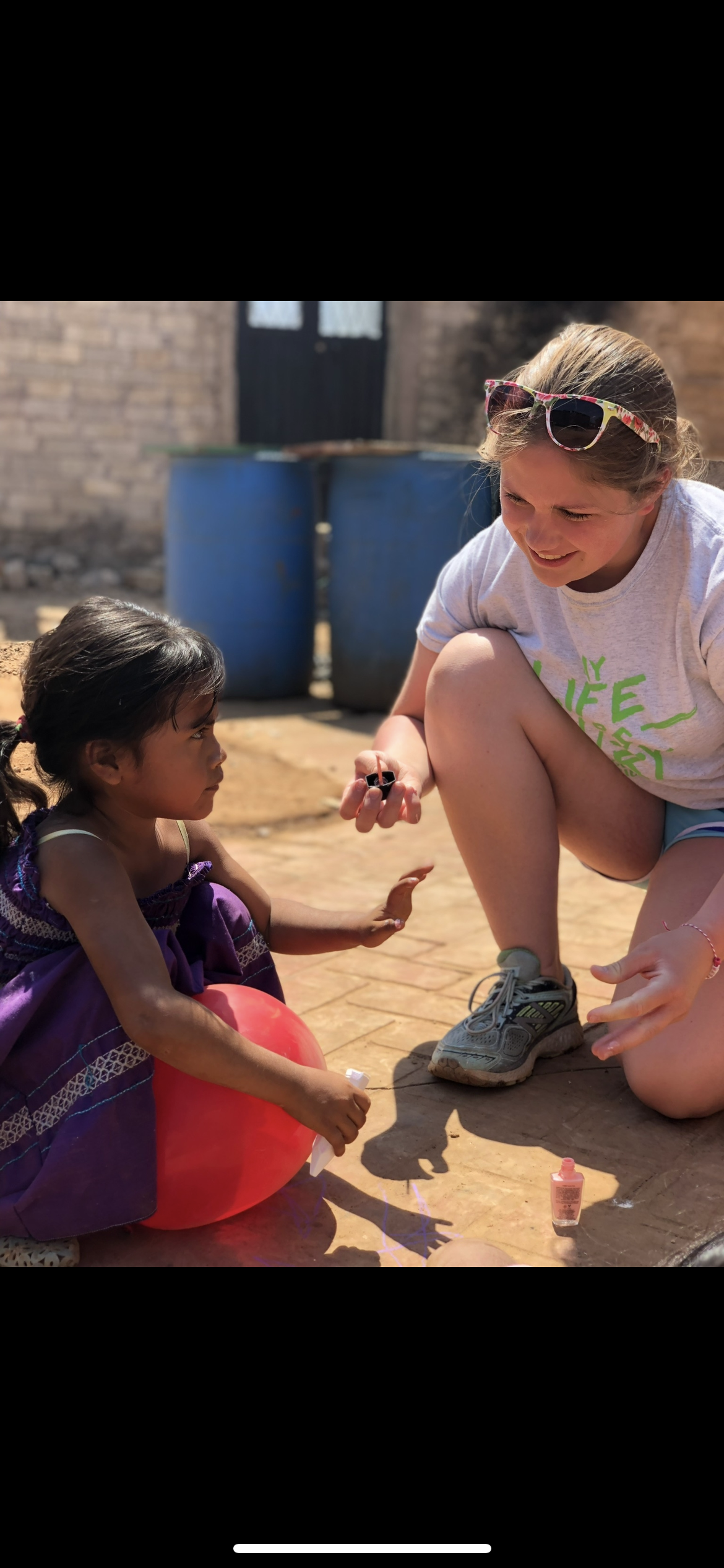A woman and a girl sitting on the ground
