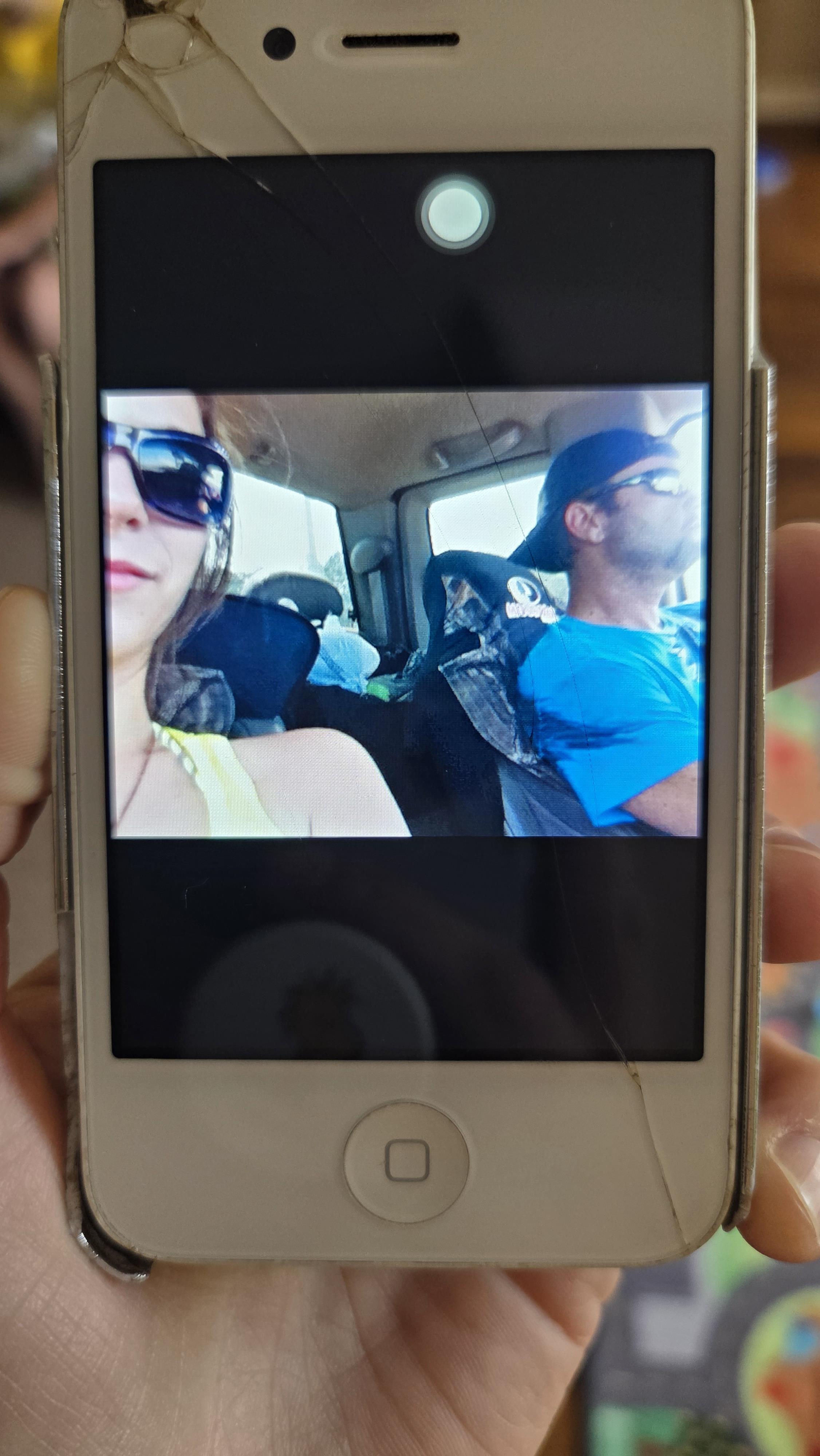 A person taking a picture of a man and woman in a car
