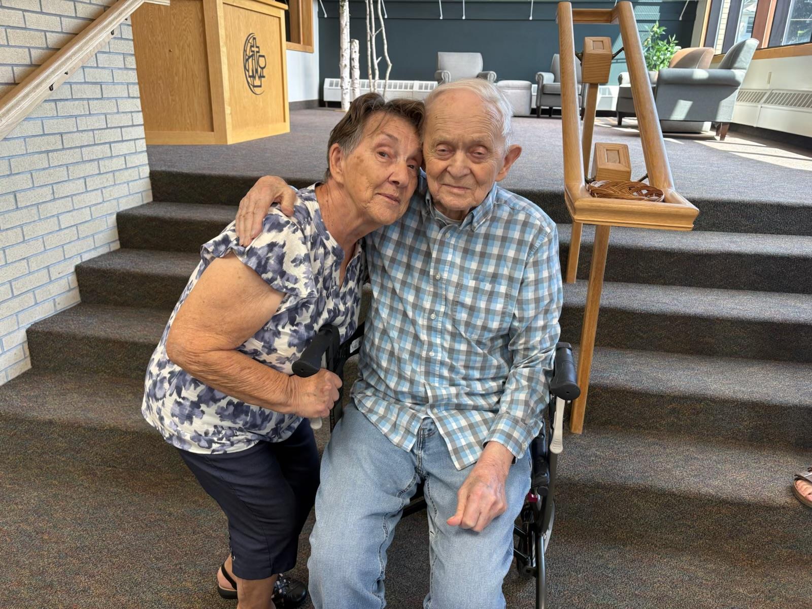 A man and woman sitting on a wheelchair