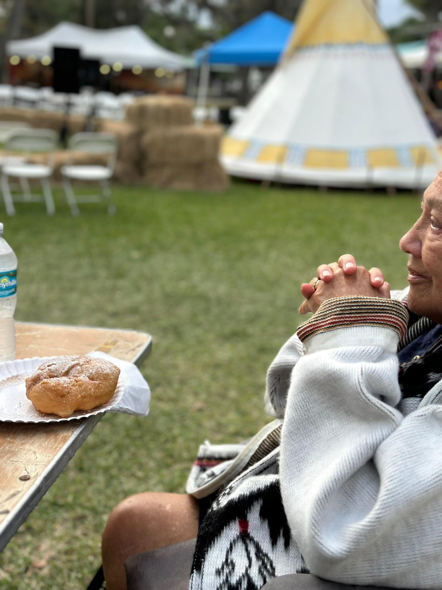 A woman sitting at a table with a donut