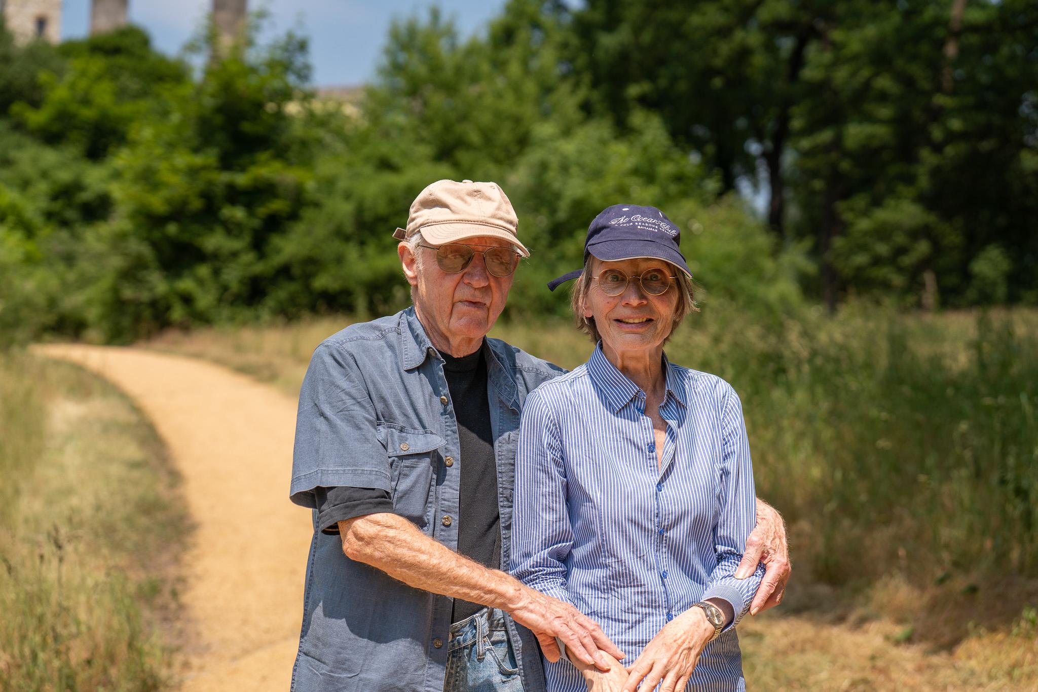 A man and woman standing on a dirt path