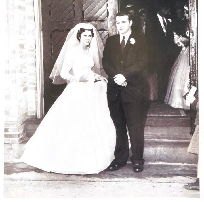 A bride and groom standing outside a church