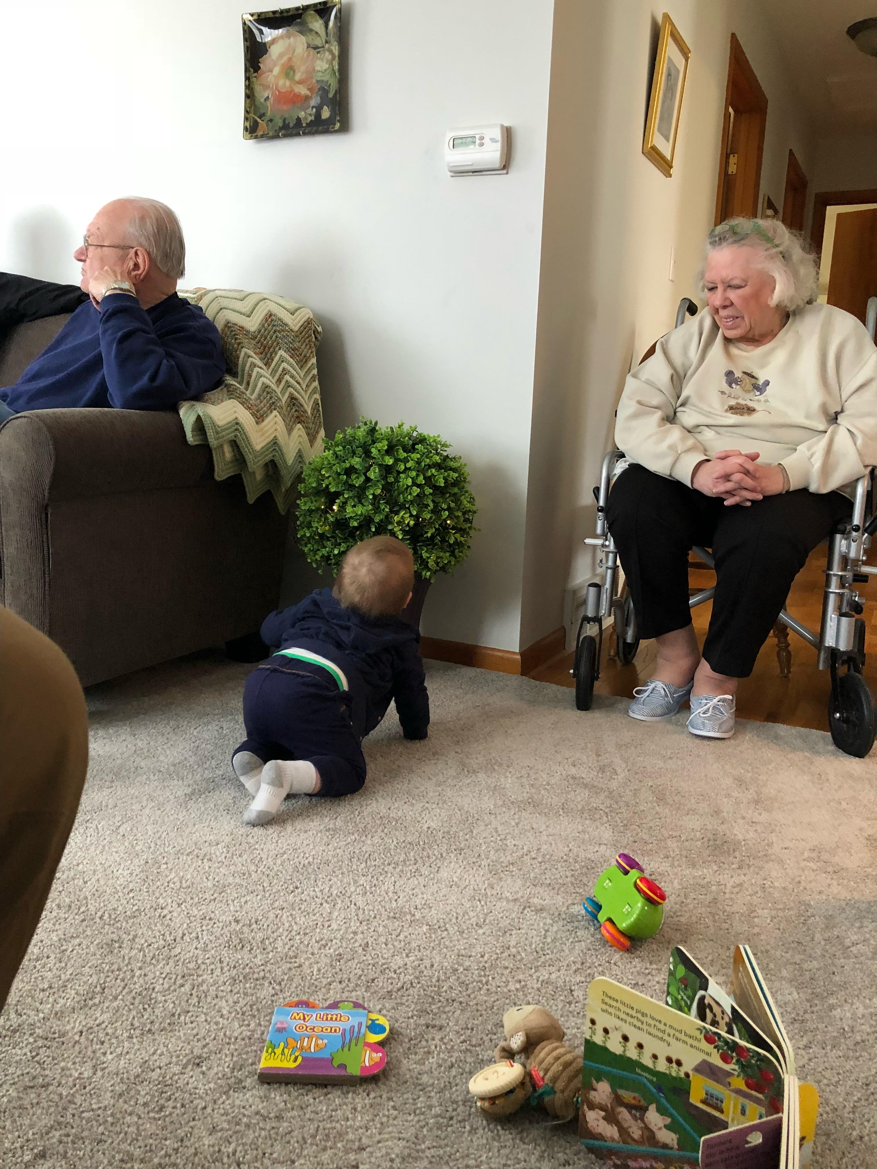 A man and woman sitting on the floor with a baby