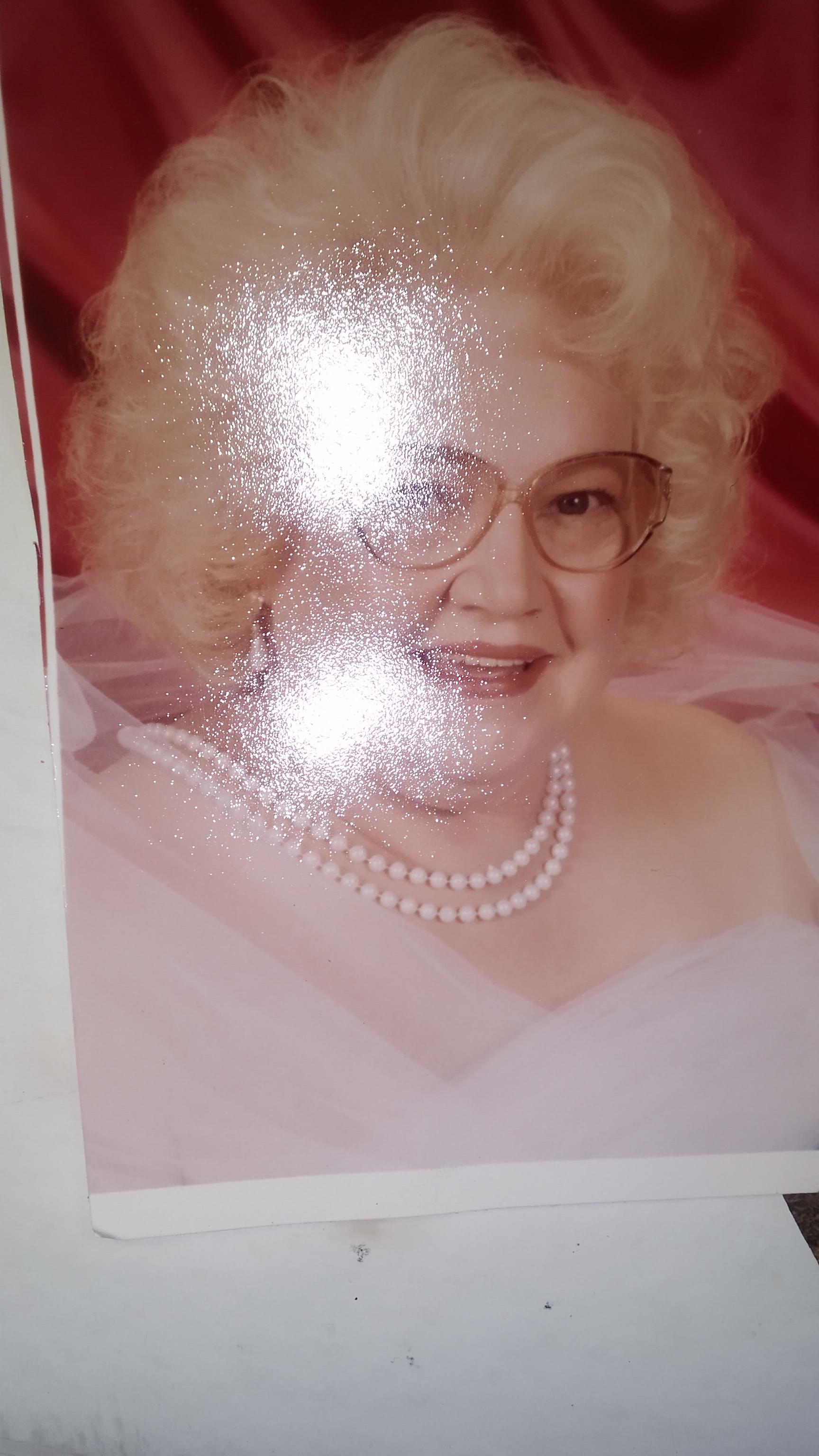 A woman with glasses and a pearl necklace