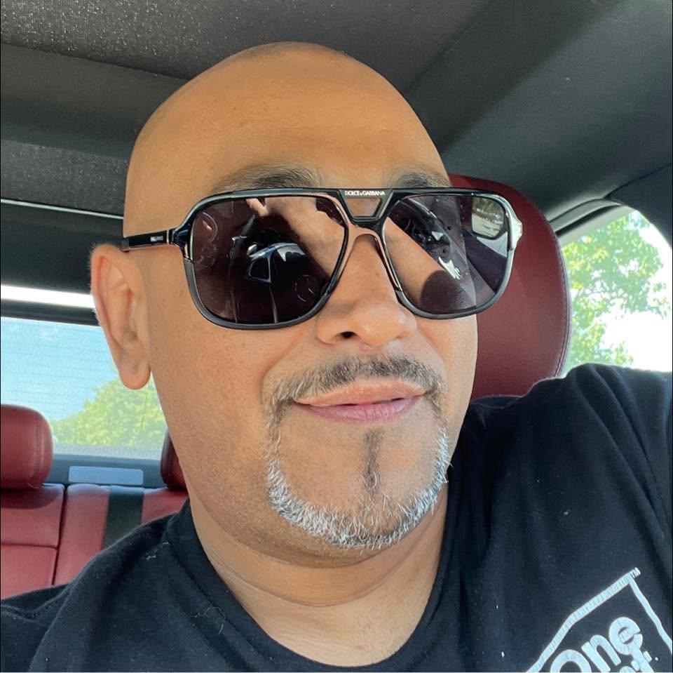 A man wearing sunglasses and taking a selfie