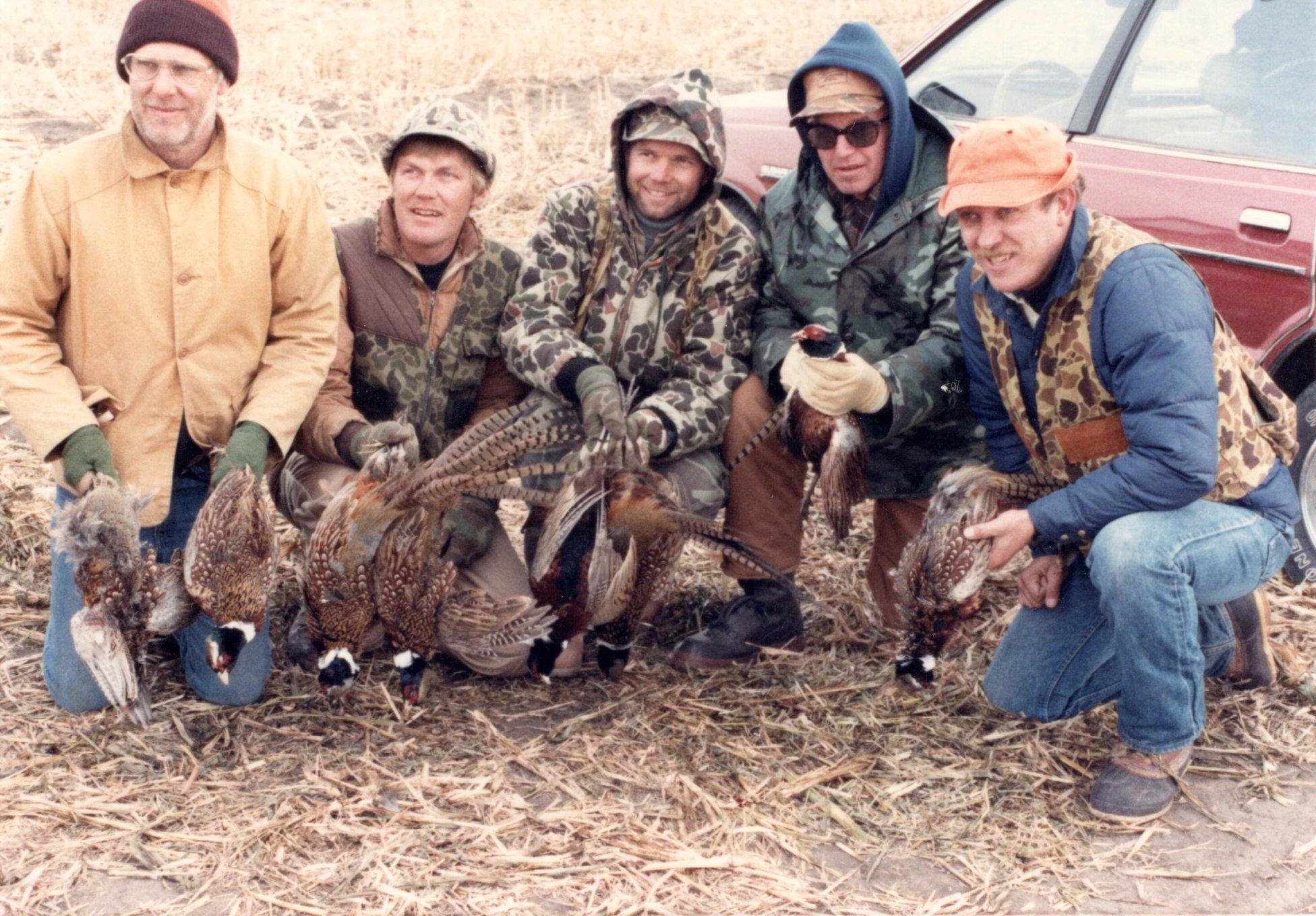 A group of men holding pheasants