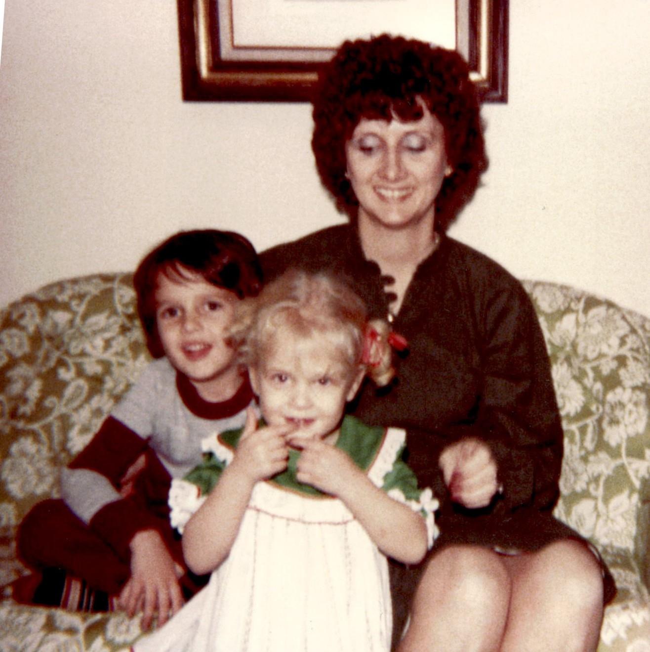 A woman and two children sitting on a couch