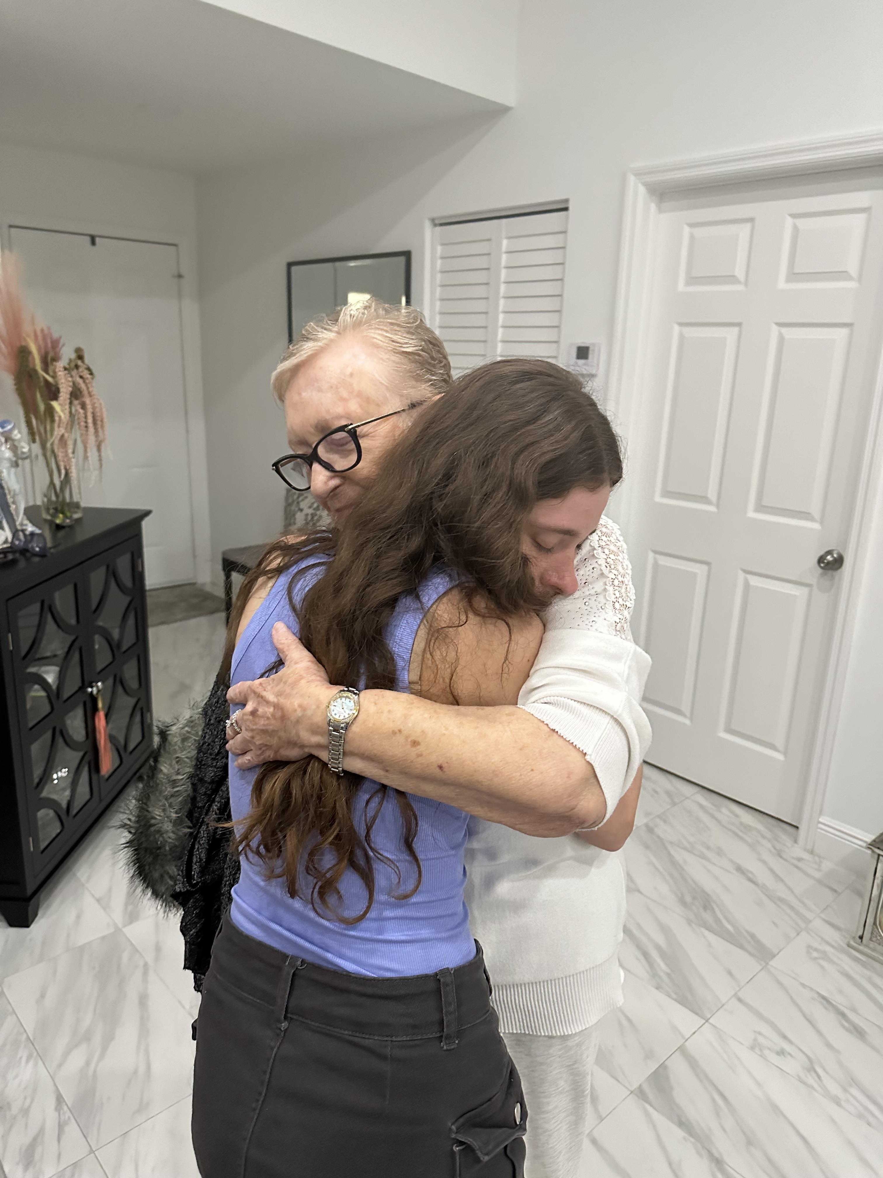 A woman hugging a woman in a room