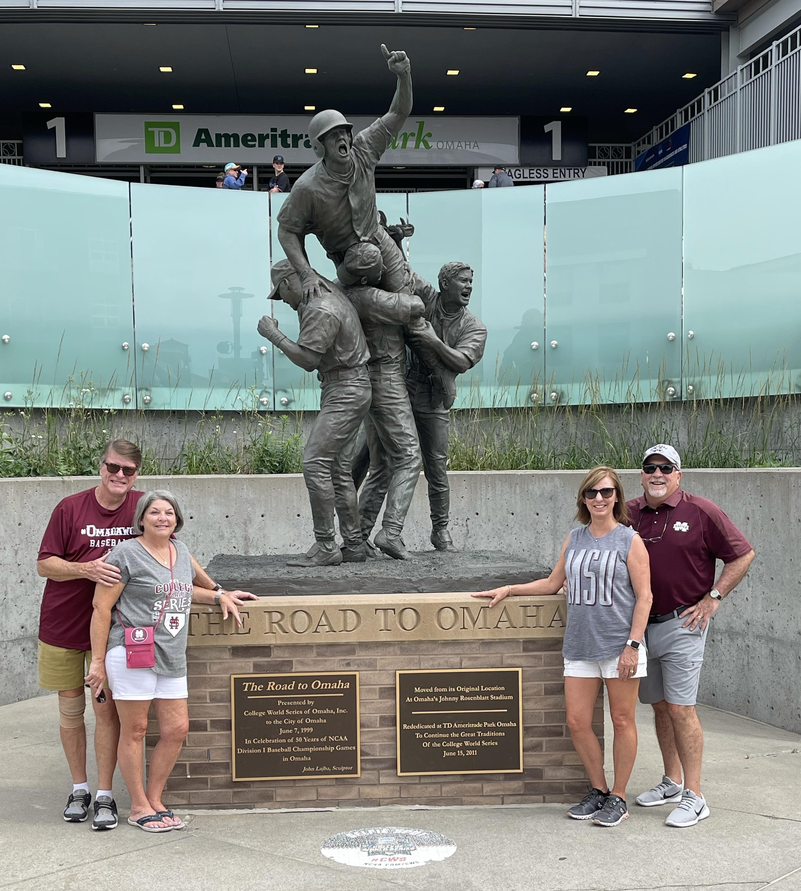 A group of people posing for a photo in front of a statue