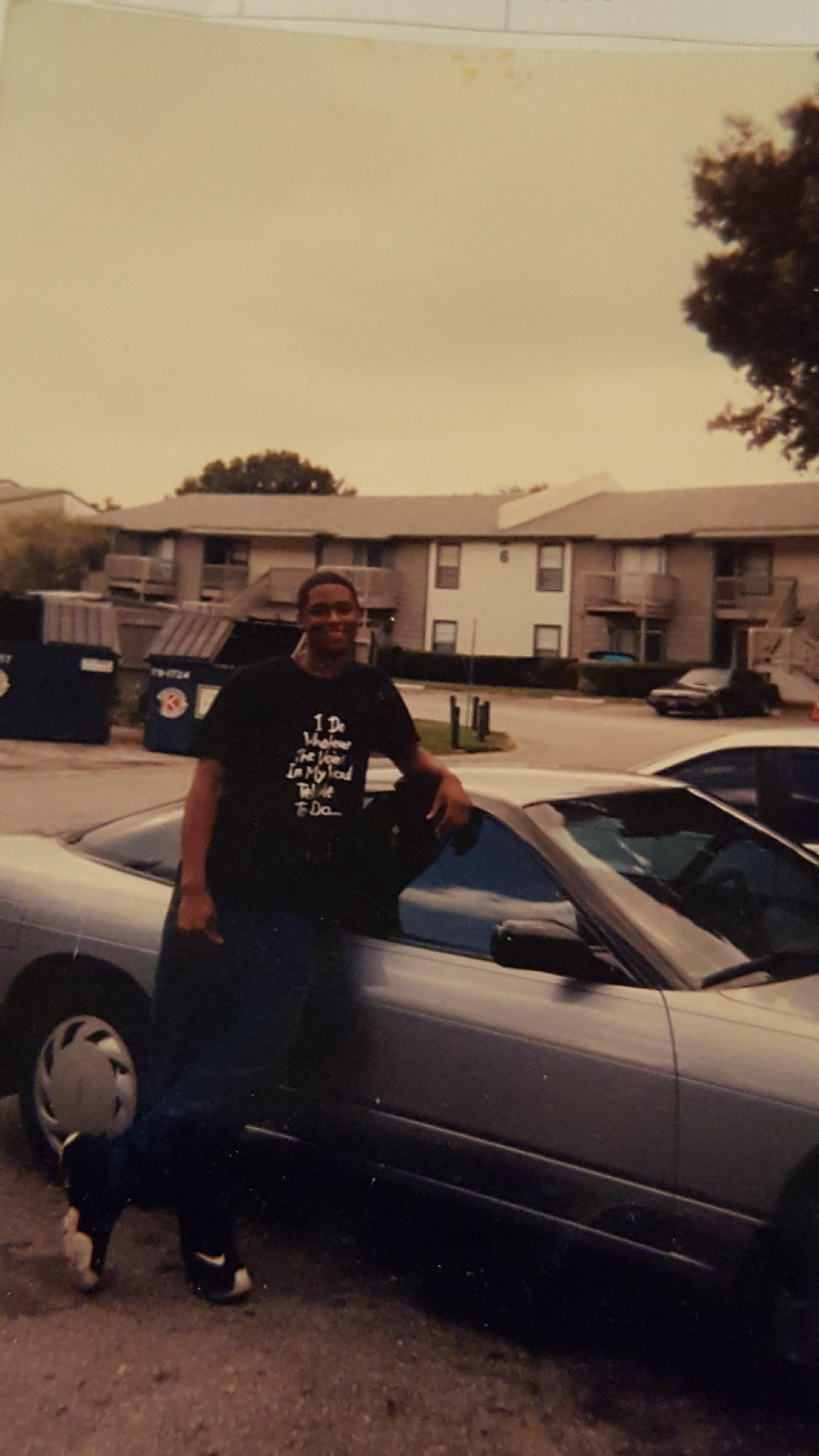 A man leaning on a car