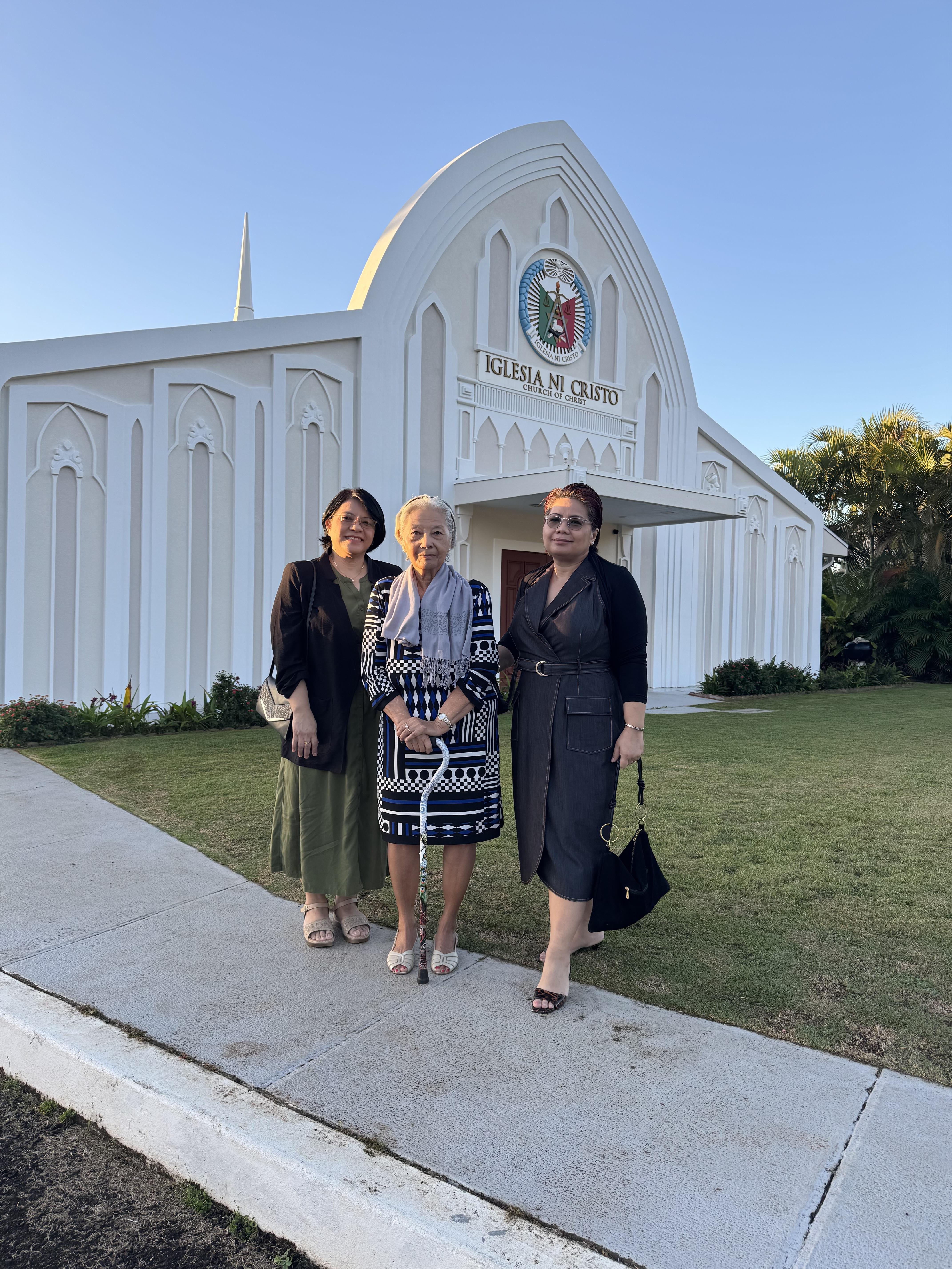 A group of women standing in front of a white building