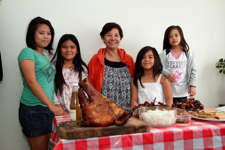 A group of people standing next to a table full of food