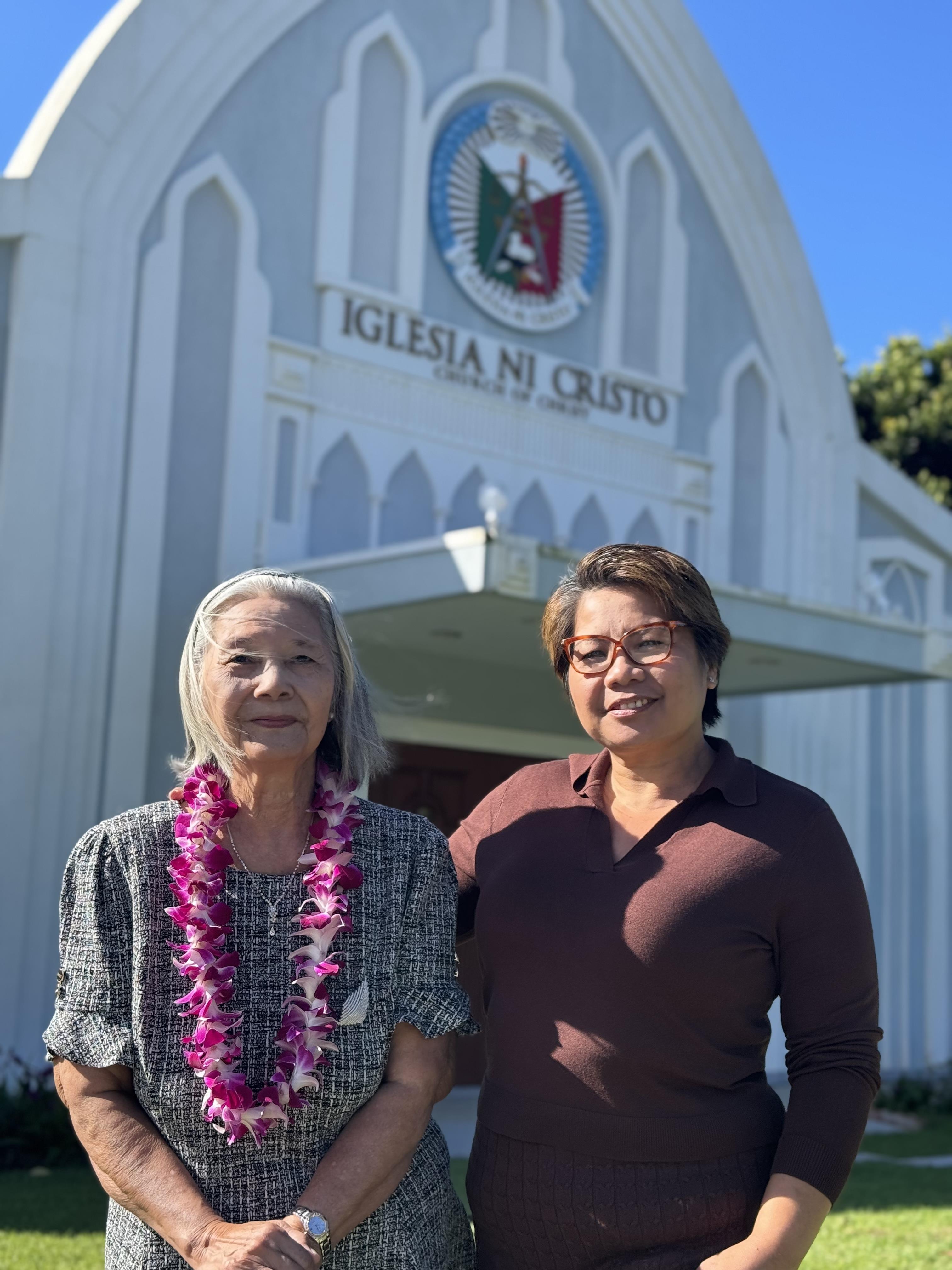 Two women standing in front of a building