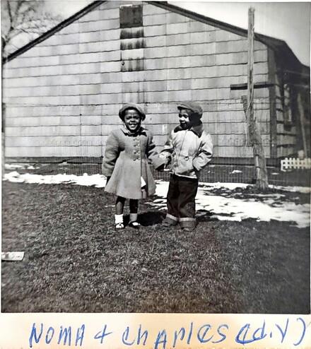 A couple of children standing in front of a building