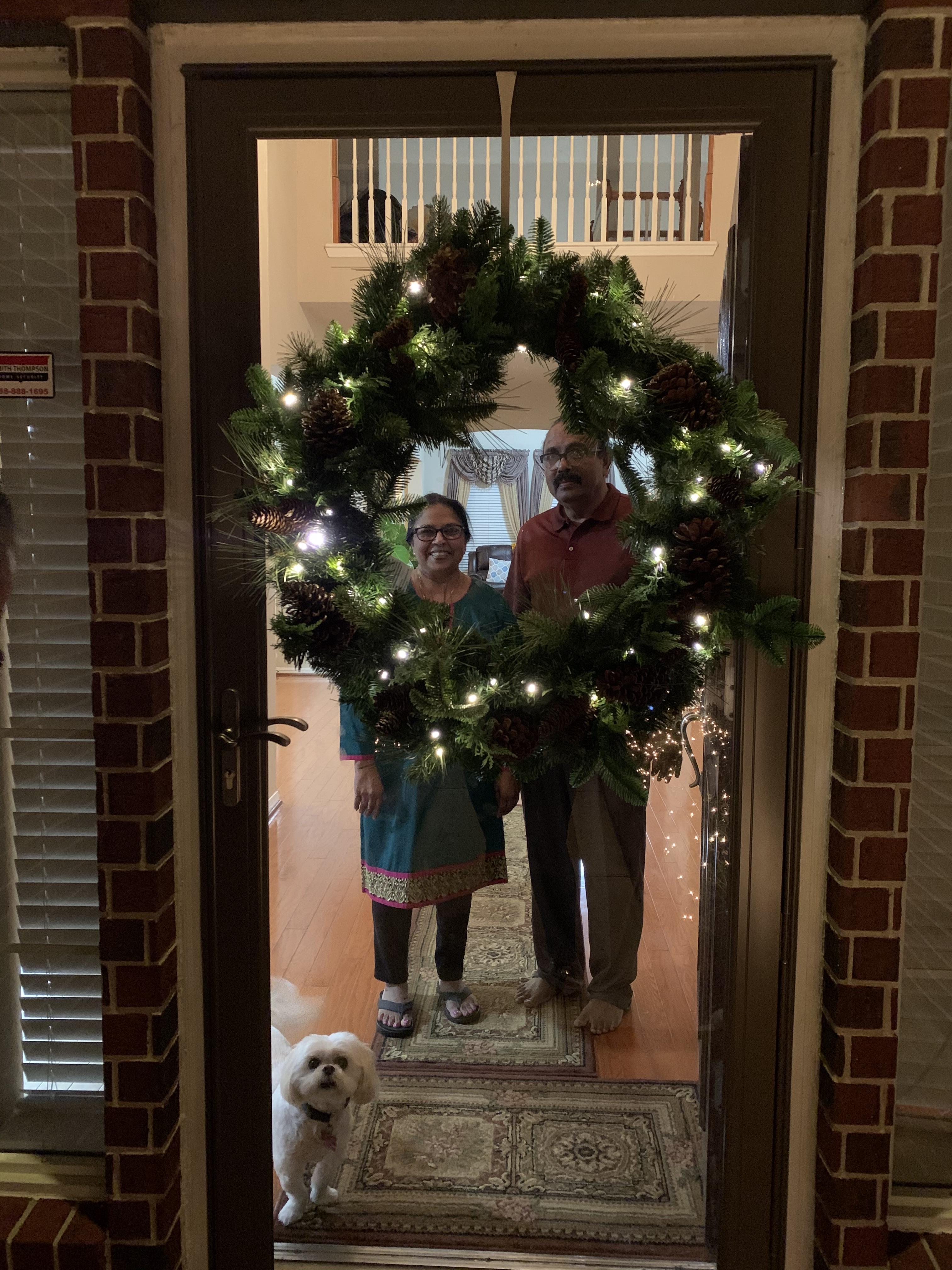 A couple standing in front of a mirror with a wreath