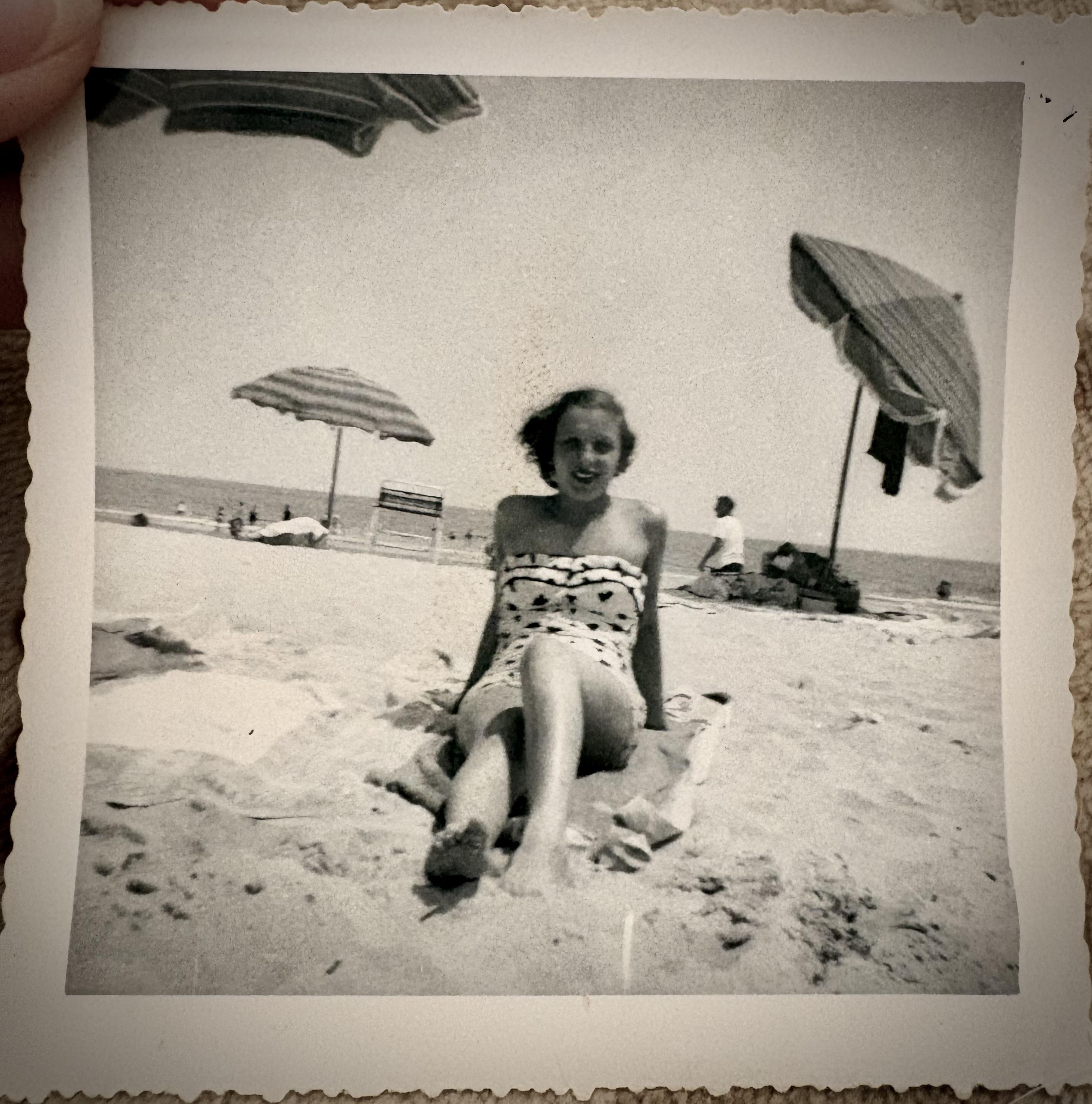 A woman sitting on a towel on the beach