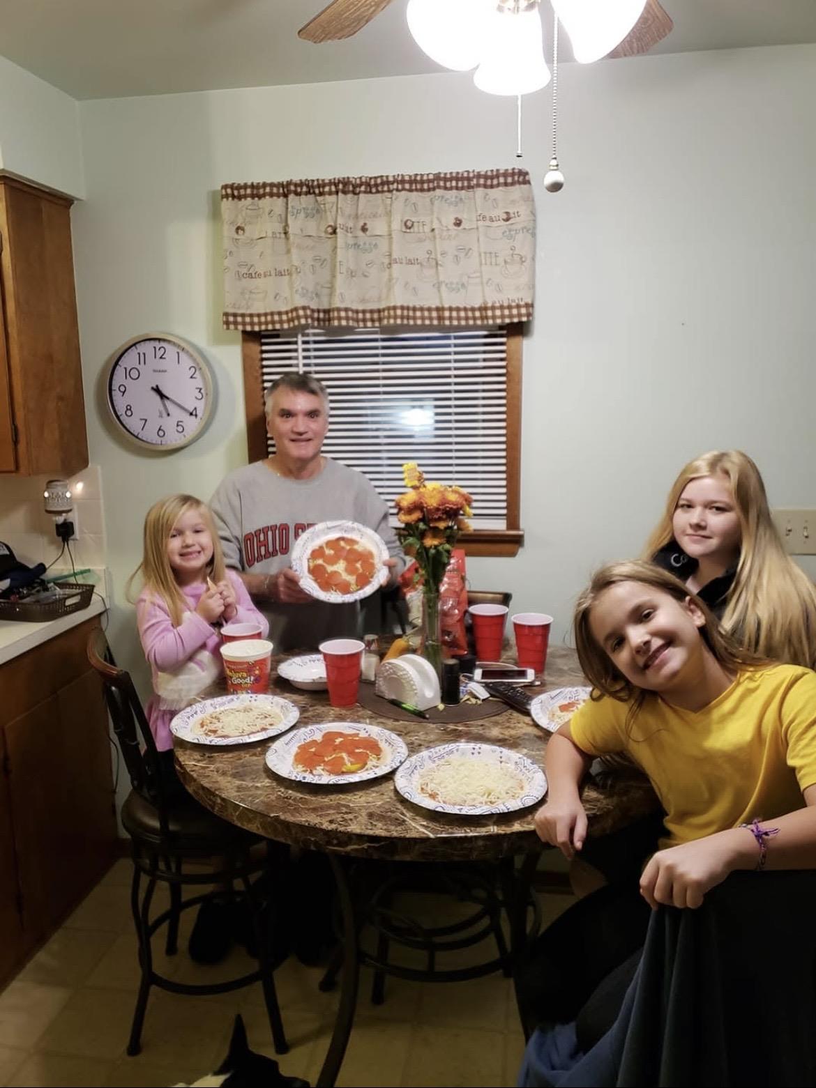 A group of people sitting at a table with plates of pizza