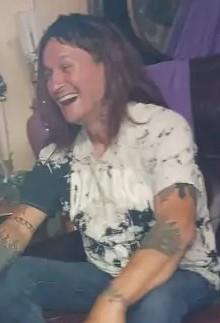 A man laughing with long hair