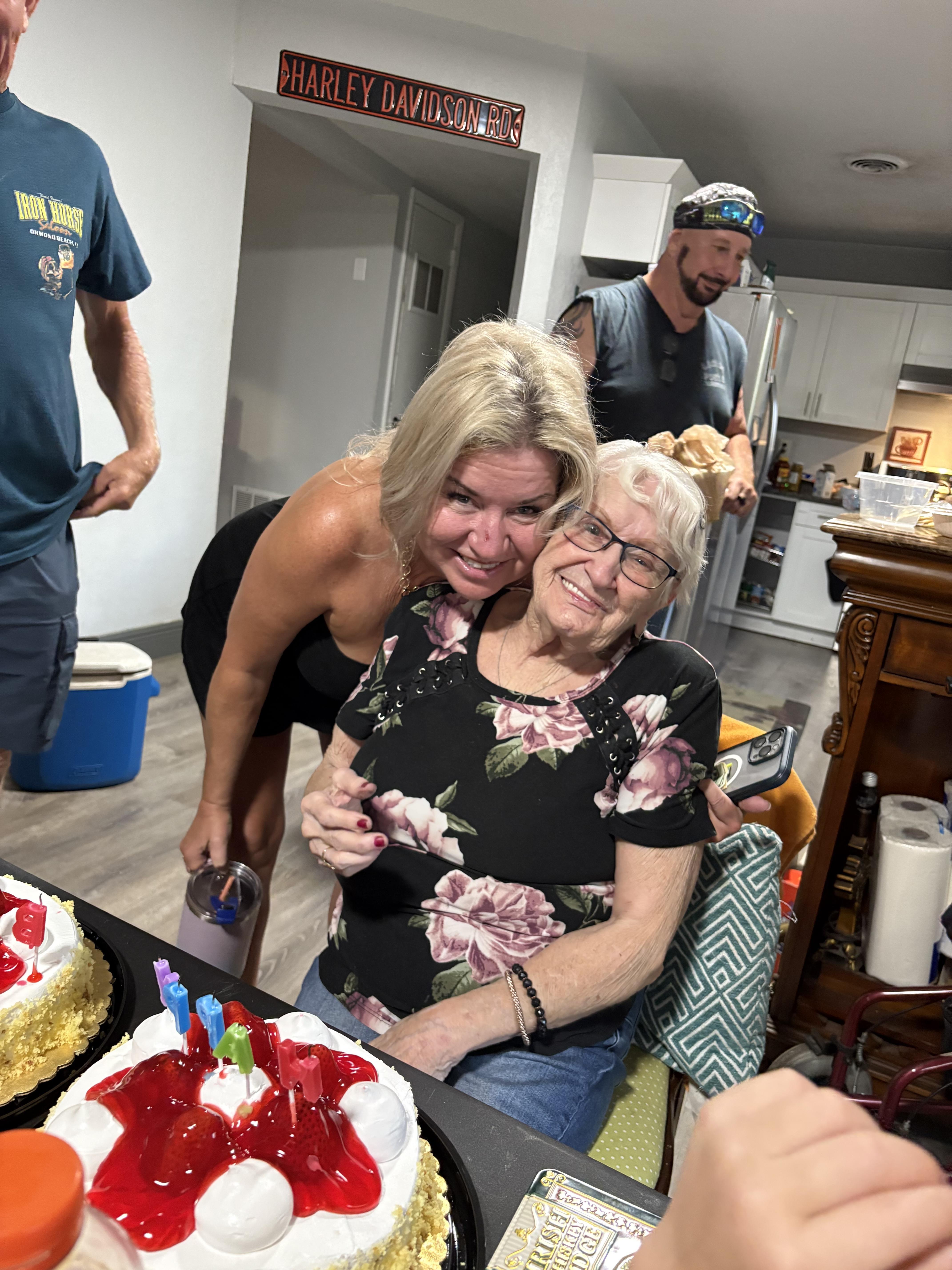 A woman hugging an older woman in a kitchen