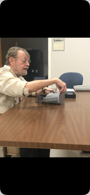 A man putting a grey object on a table