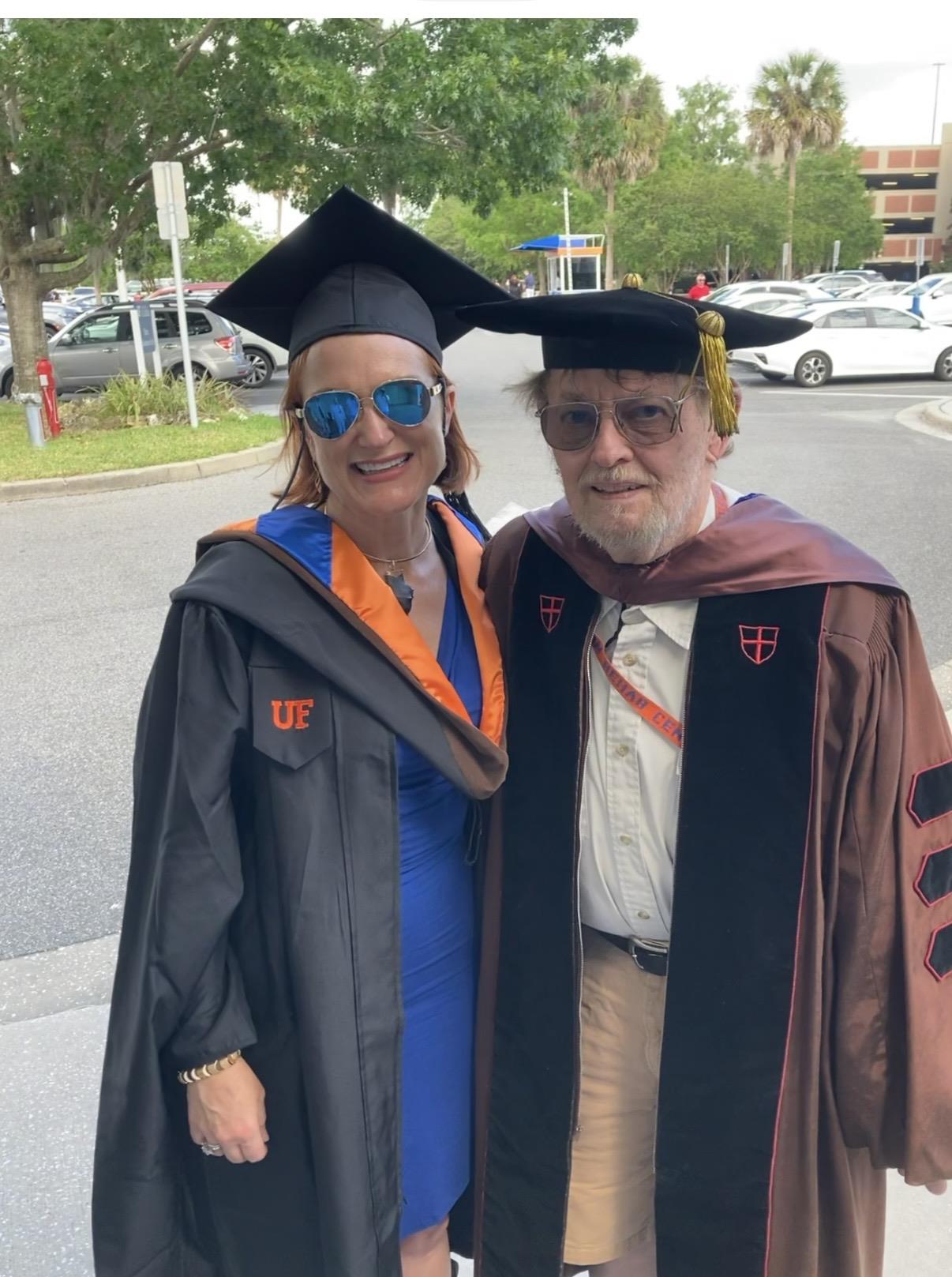 A man and woman in graduation gowns