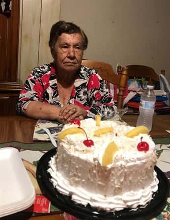 A woman sitting at a table with a cake