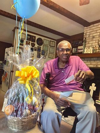 A man sitting in a chair with a balloon and a gift bag
