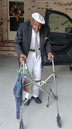 A man in a suit pushing a walker