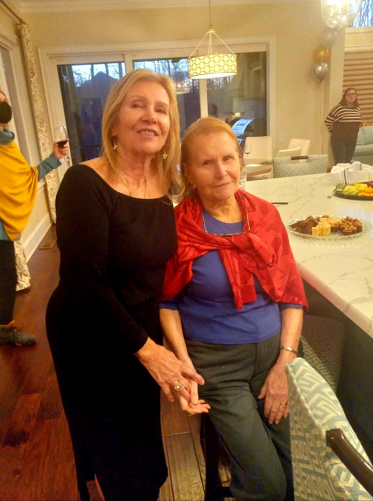 Two women holding hands in a room