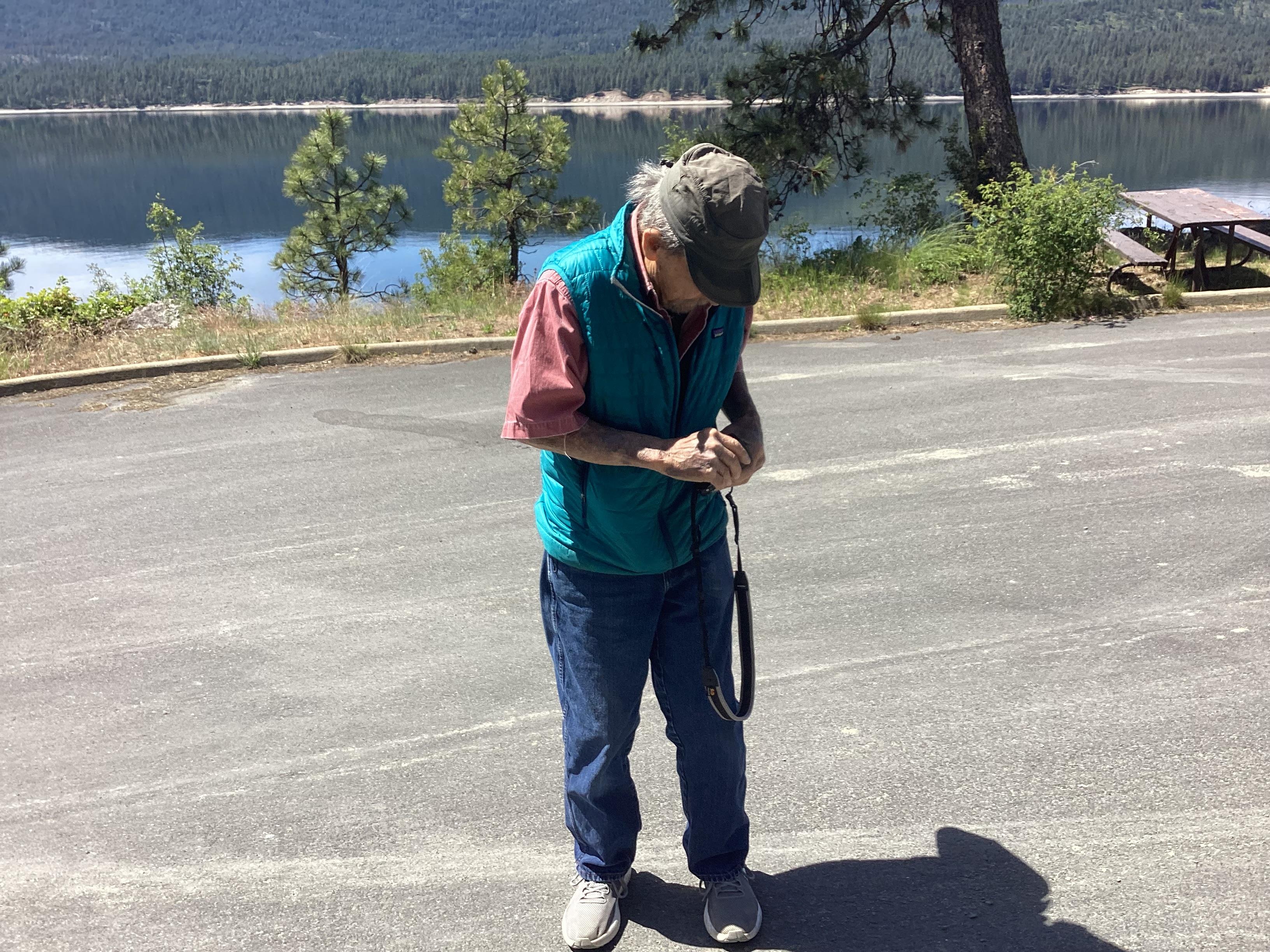 A man standing outside with his hands on his wrist