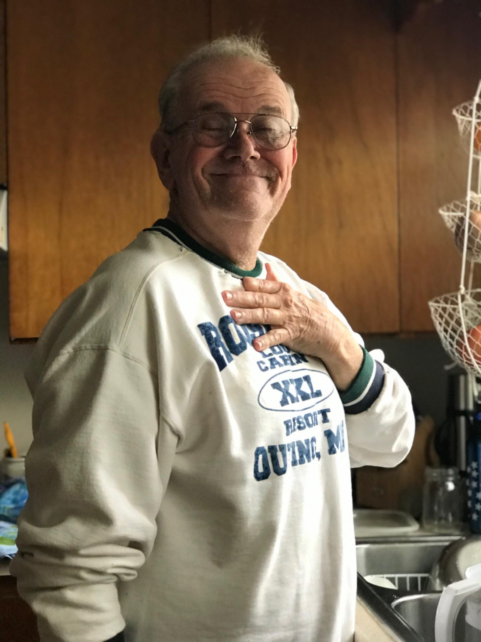 A man smiling with his hand on his heart
