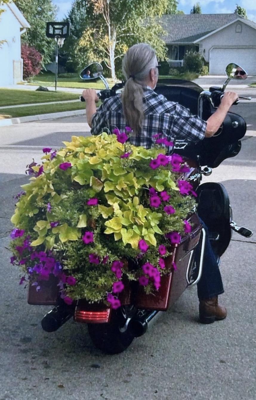 A man on a motorcycle with flowers