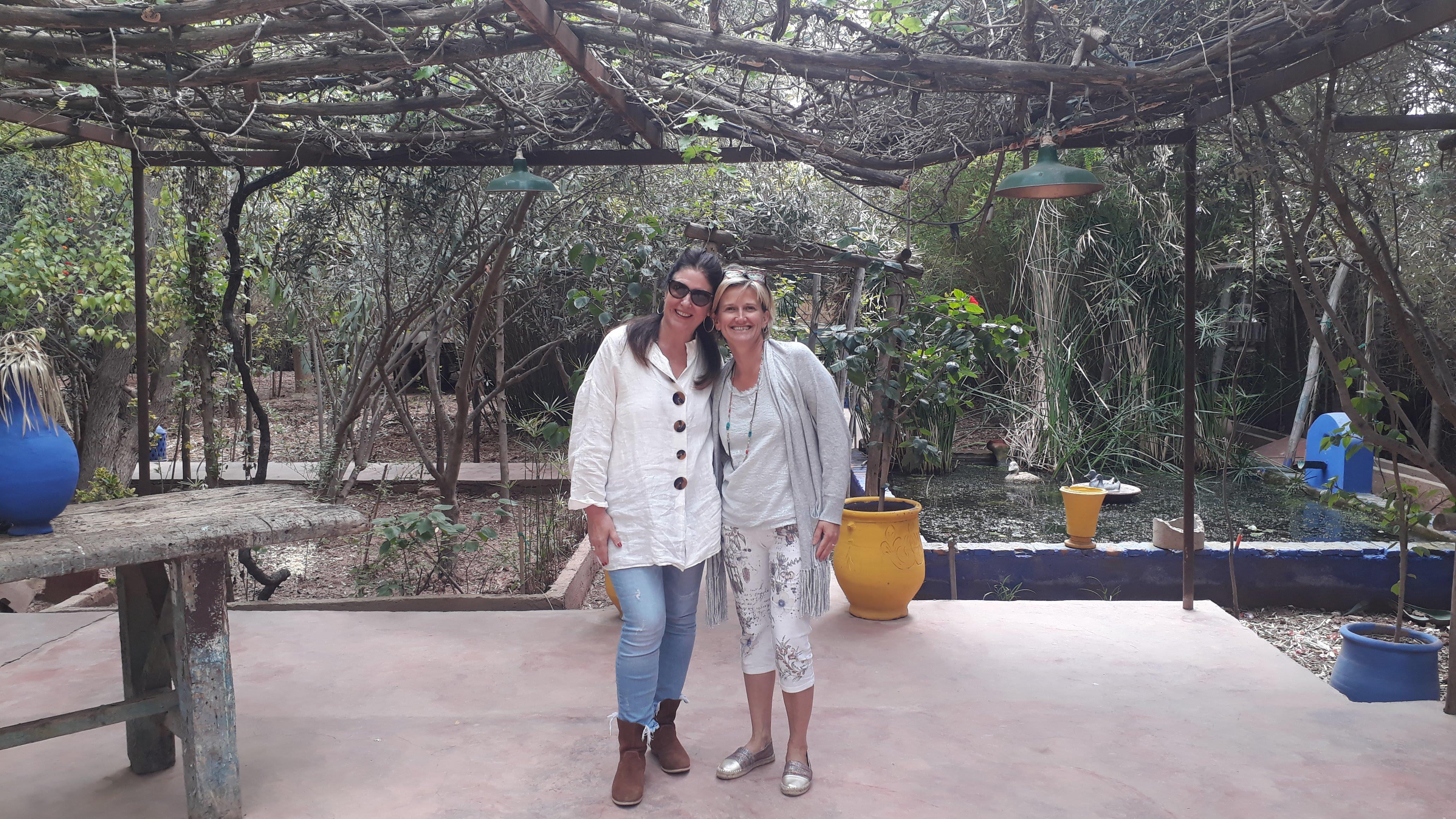 Two women standing under a tree
