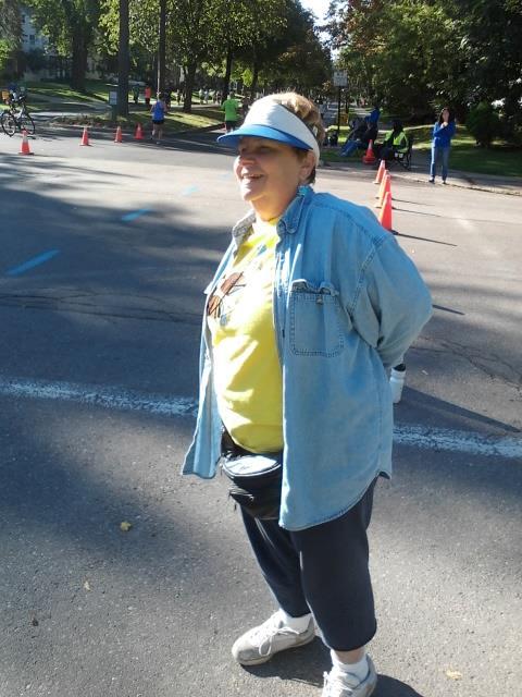A woman in a blue shirt and sun visor