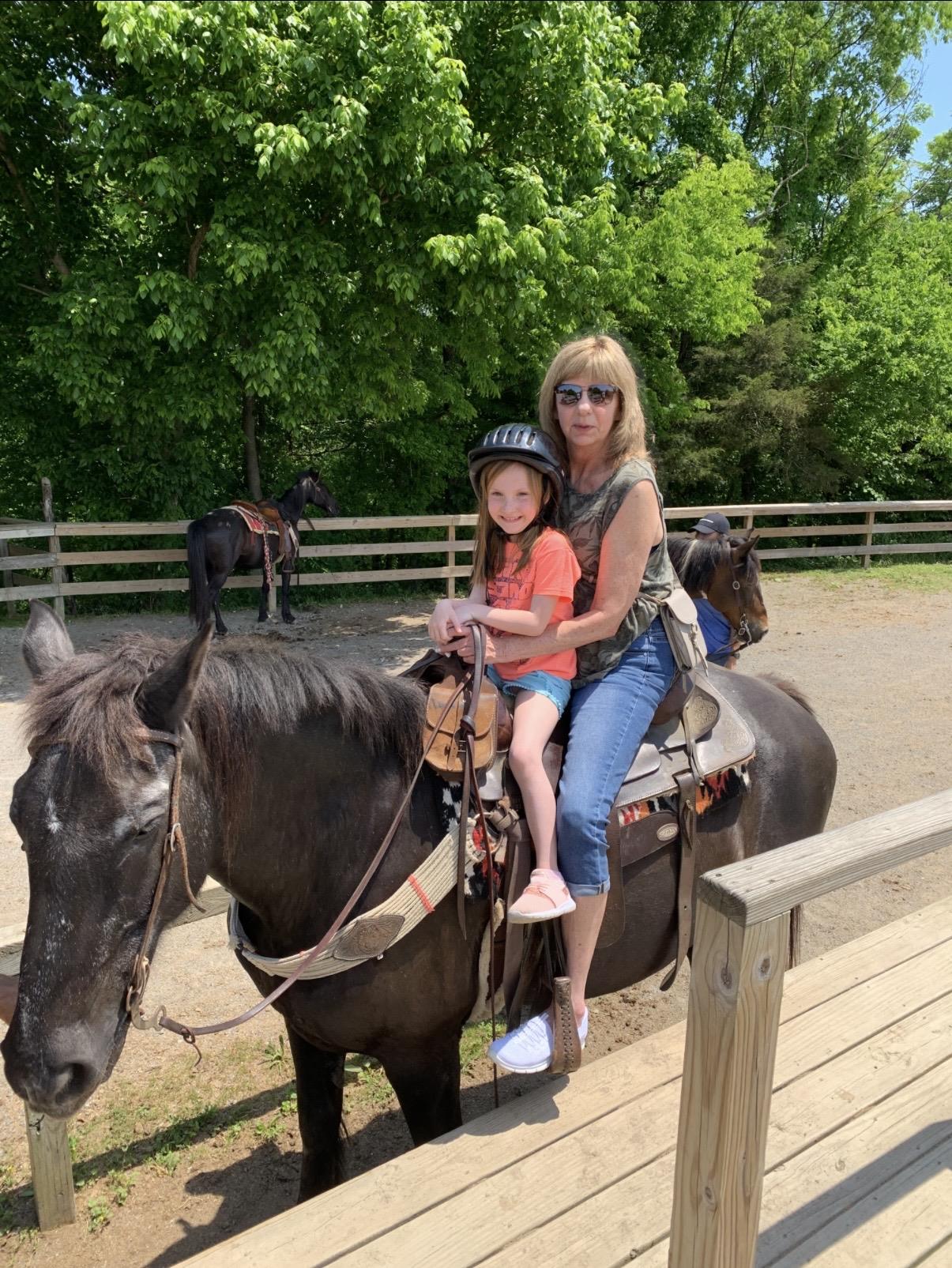 A woman and a girl riding a horse