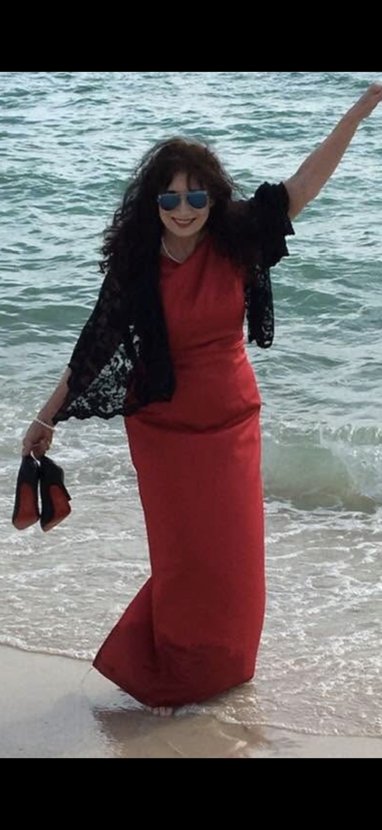 A woman in a red dress holding shoes