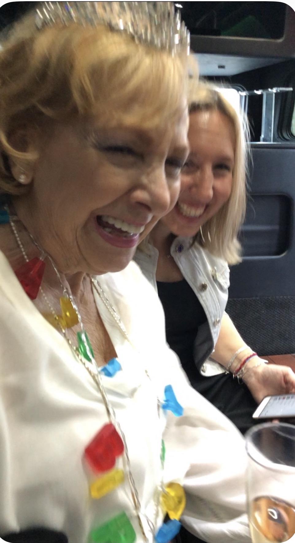 Two women laughing and sitting on a bus