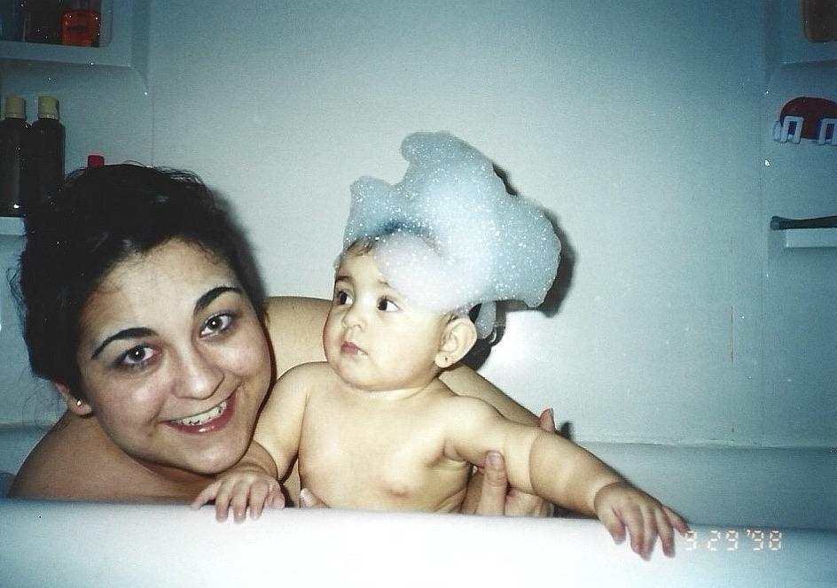 A woman holding a baby in a bathtub