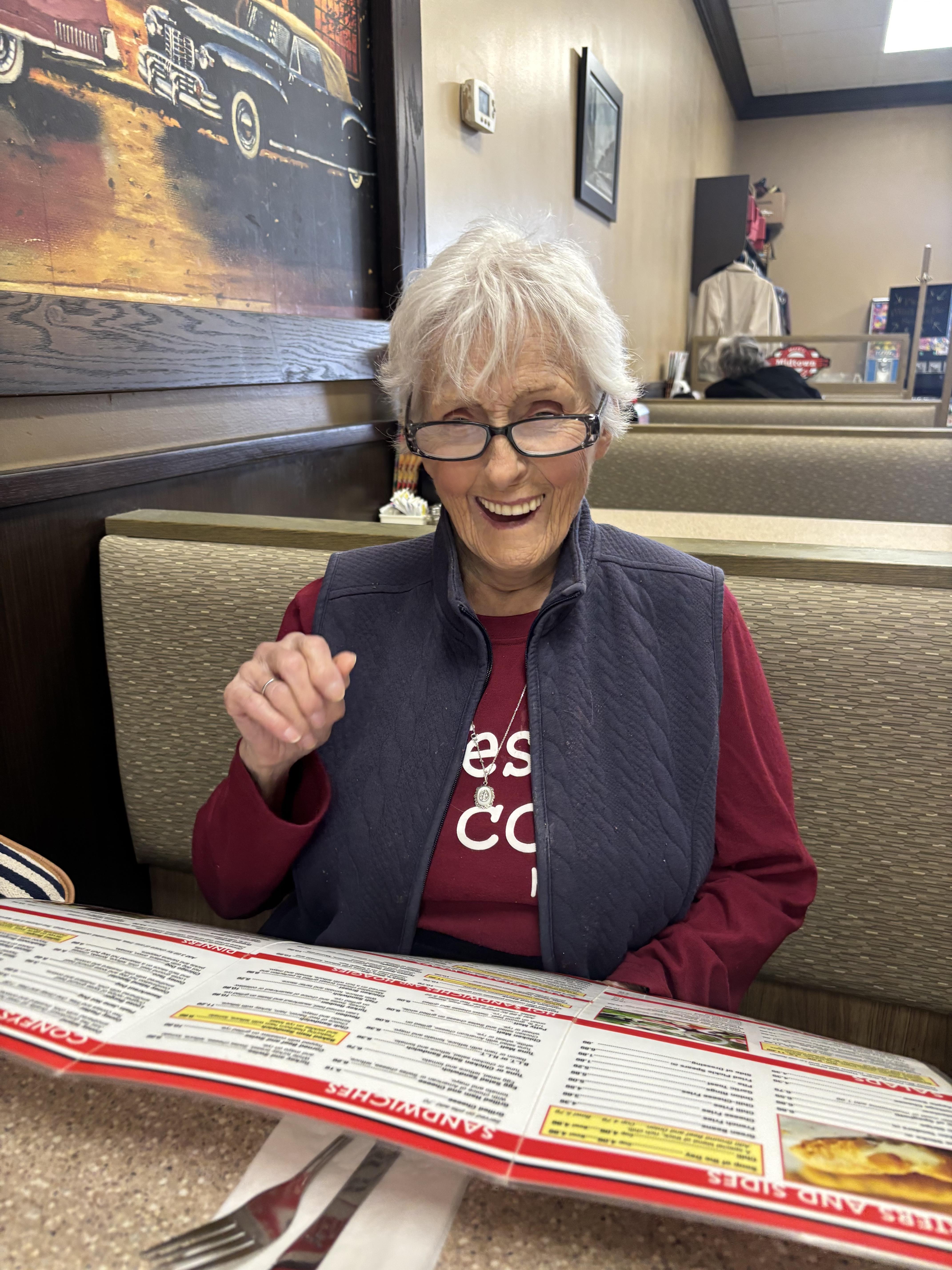 A woman sitting at a table with a newspaper