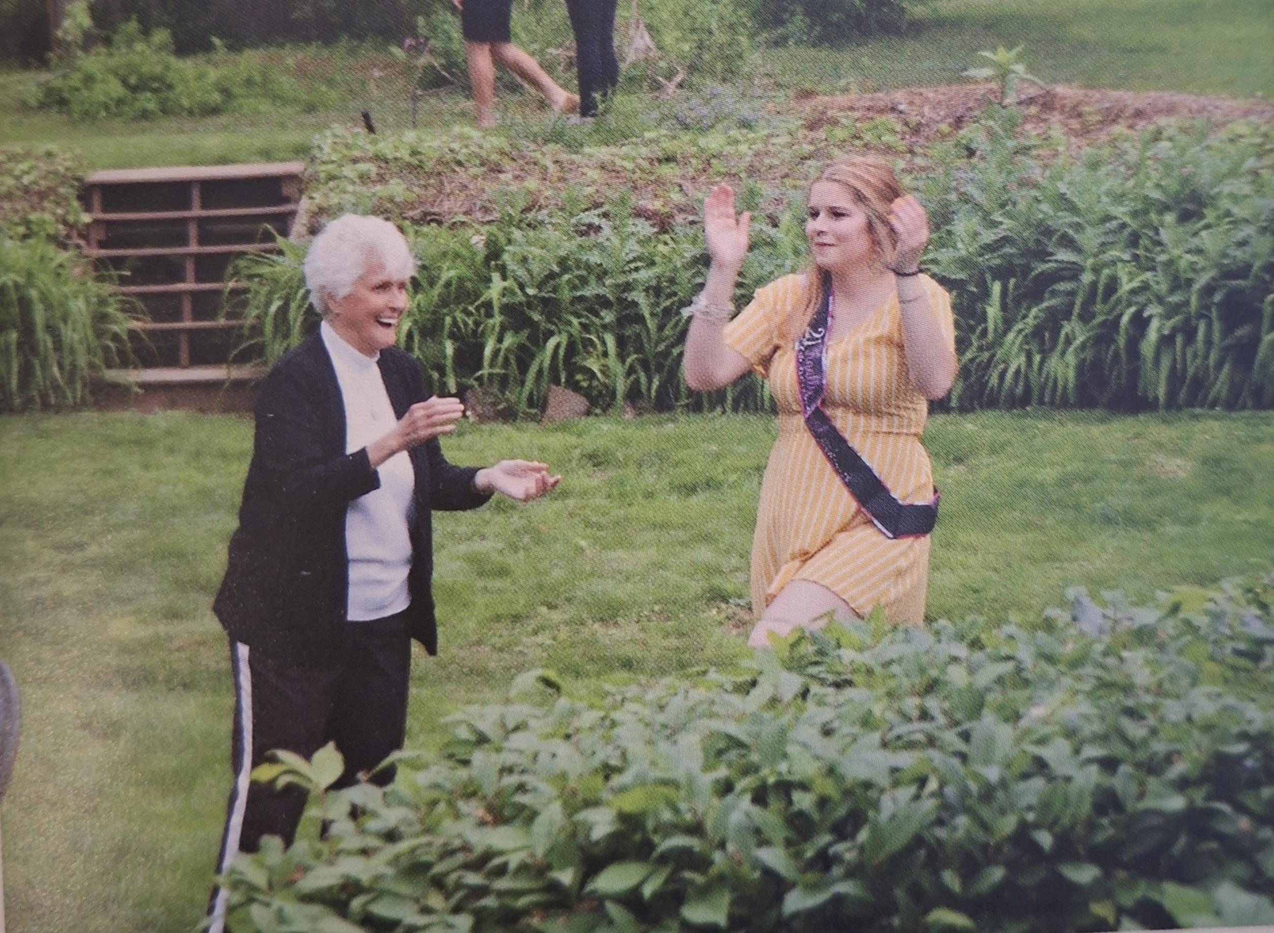 A woman standing in a garden with a woman standing in a garden