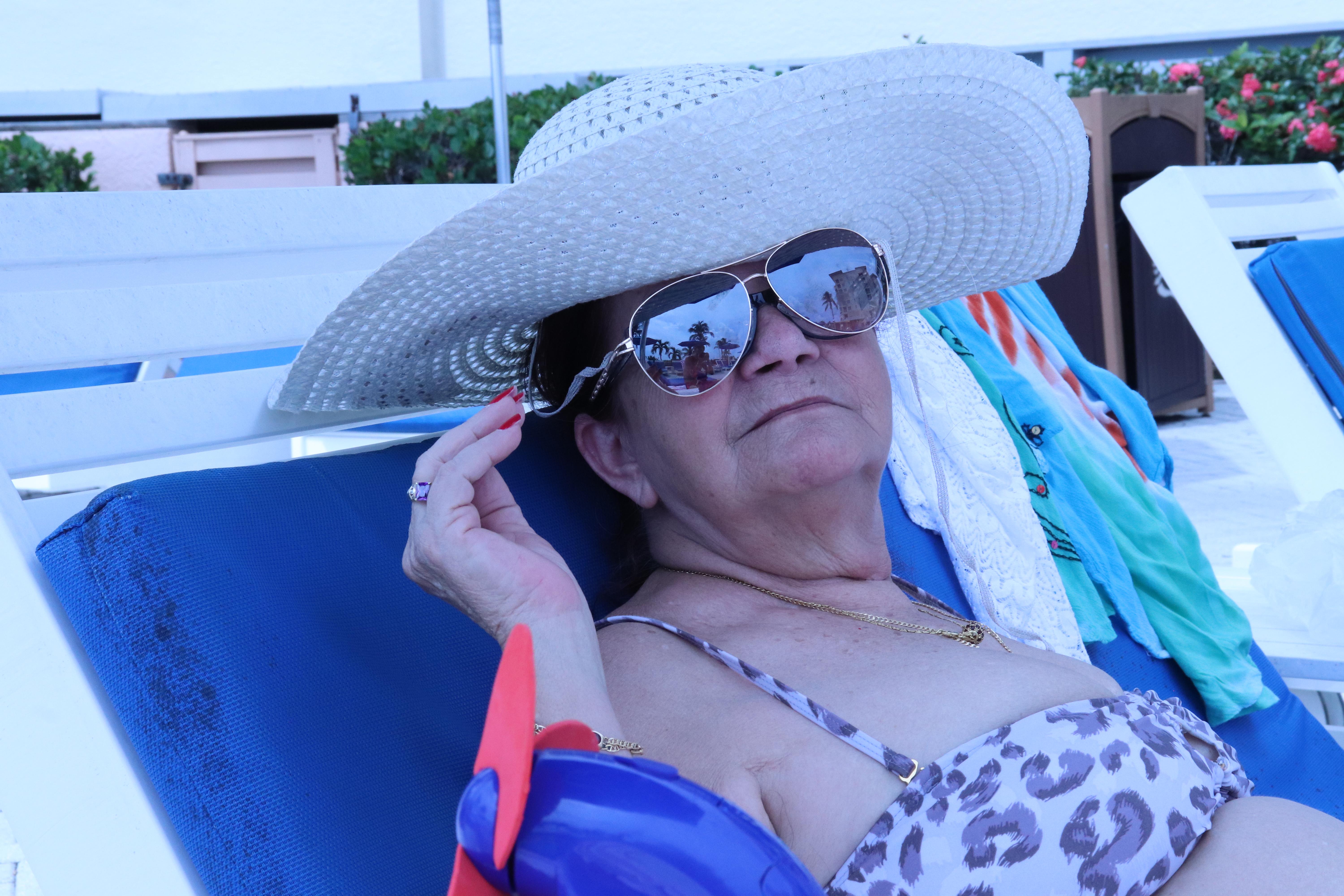 A woman wearing a hat and sunglasses