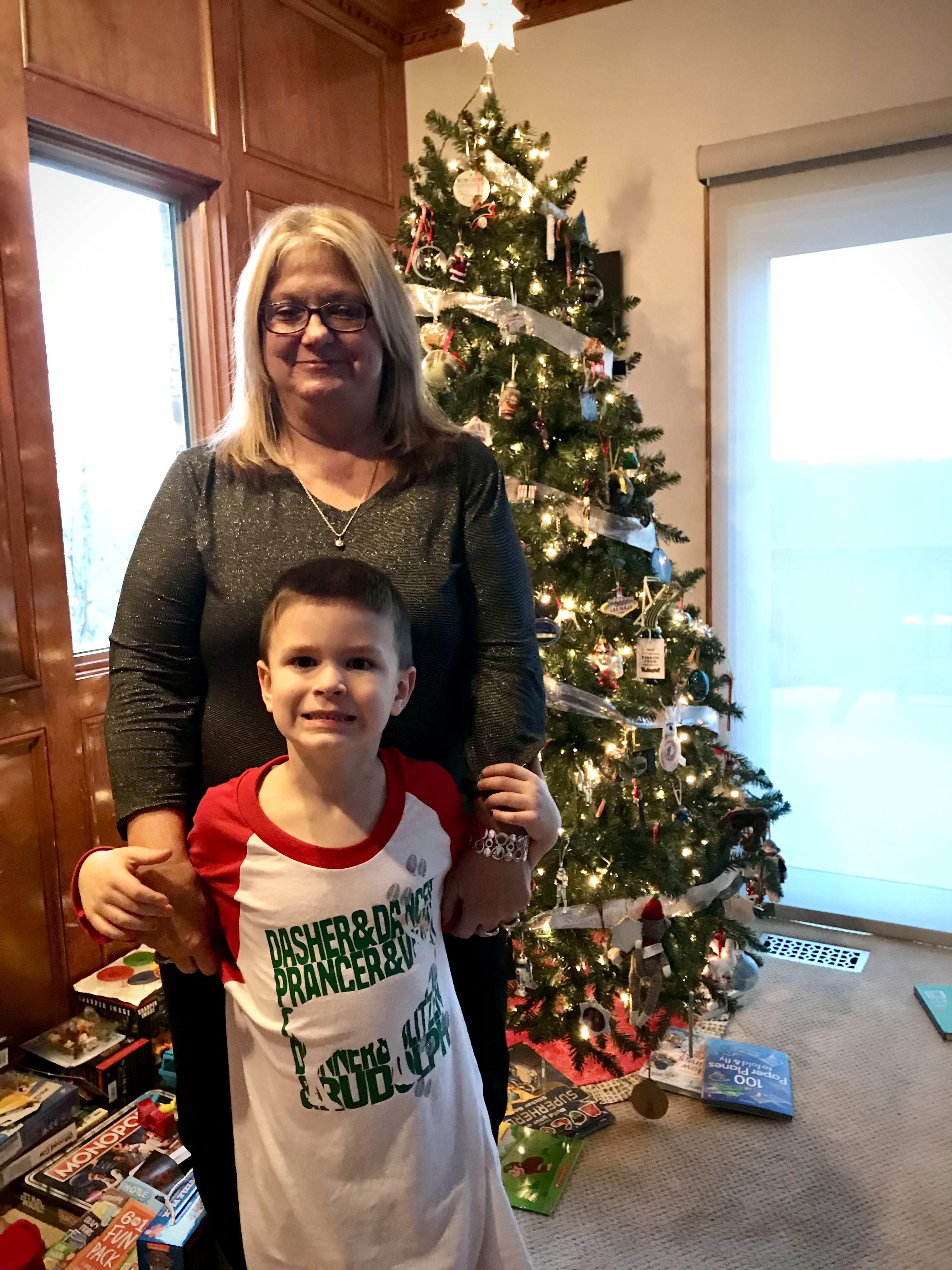 A woman and a boy standing in front of a christmas tree