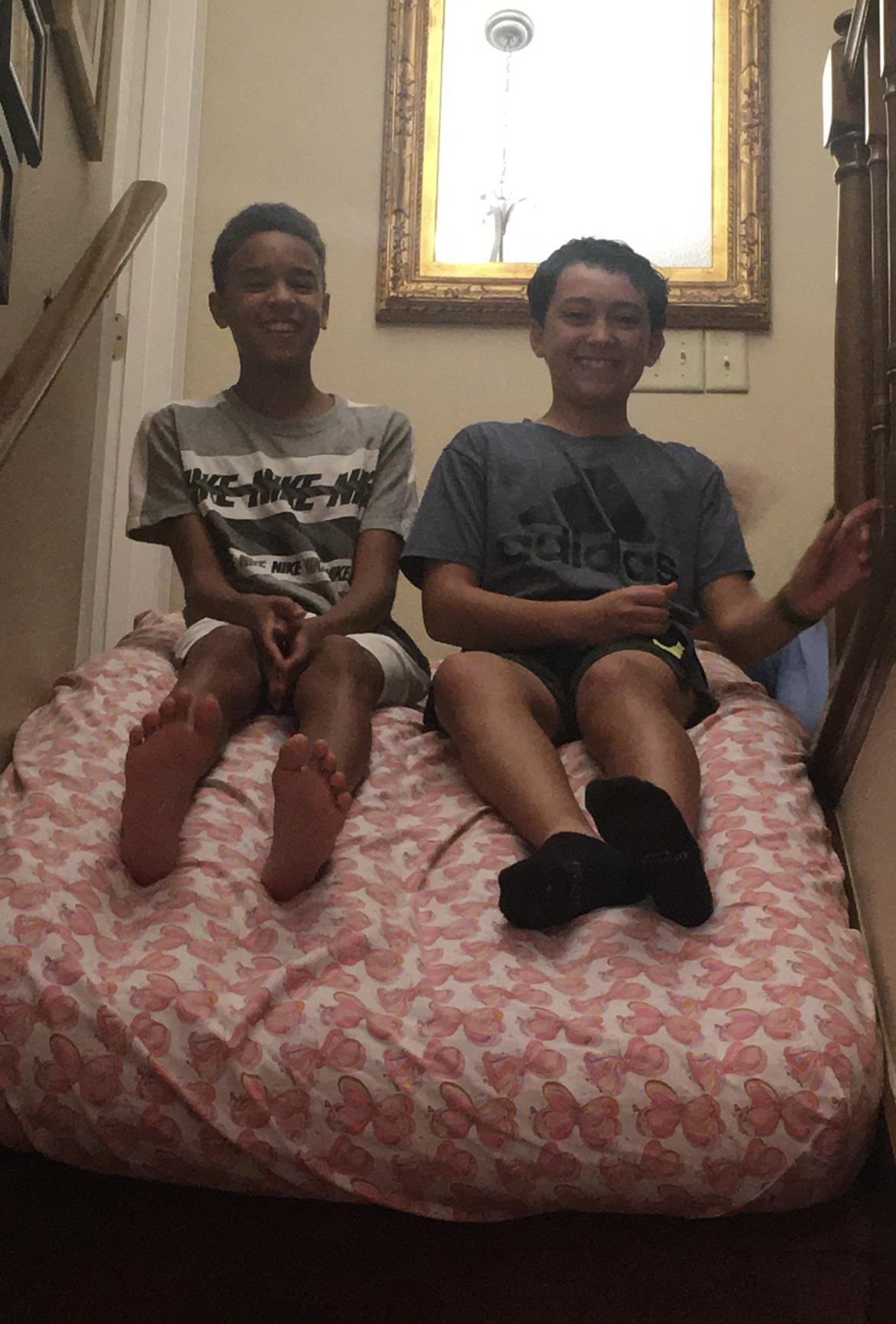 Two boys sitting on a bed