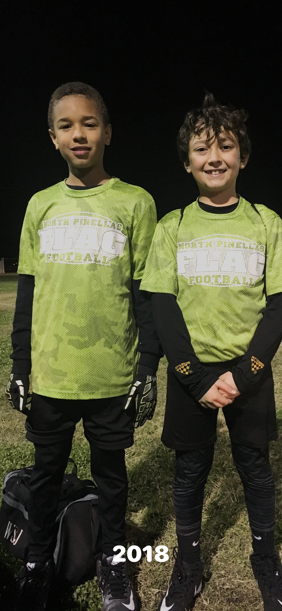 Two boys wearing football jerseys