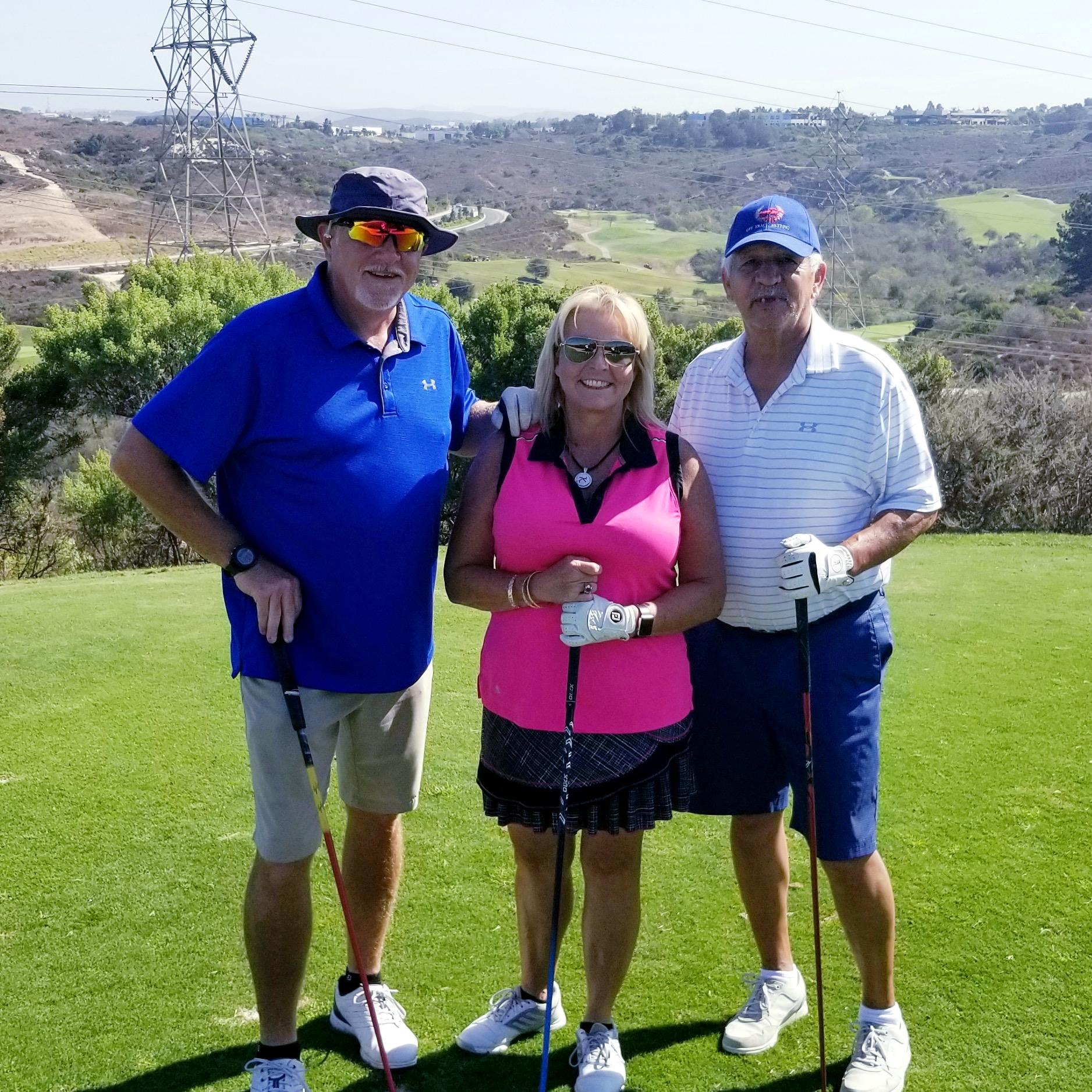 A group of people standing on a golf course