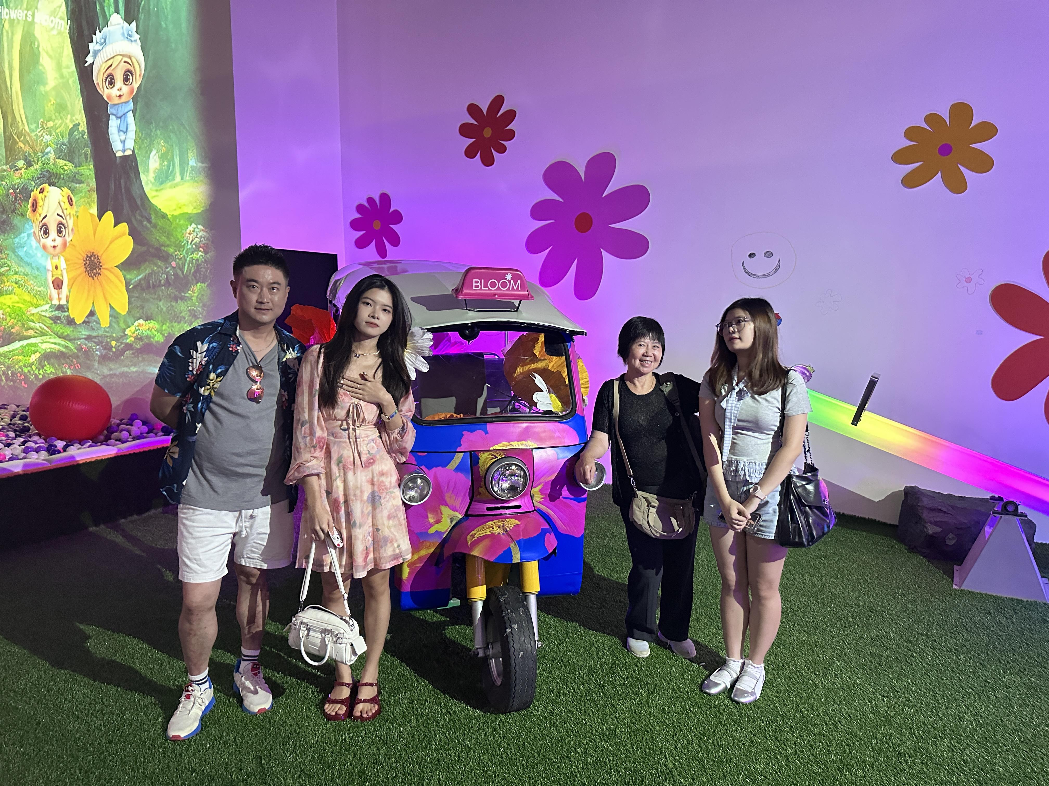 A group of people standing in front of a colorful vehicle