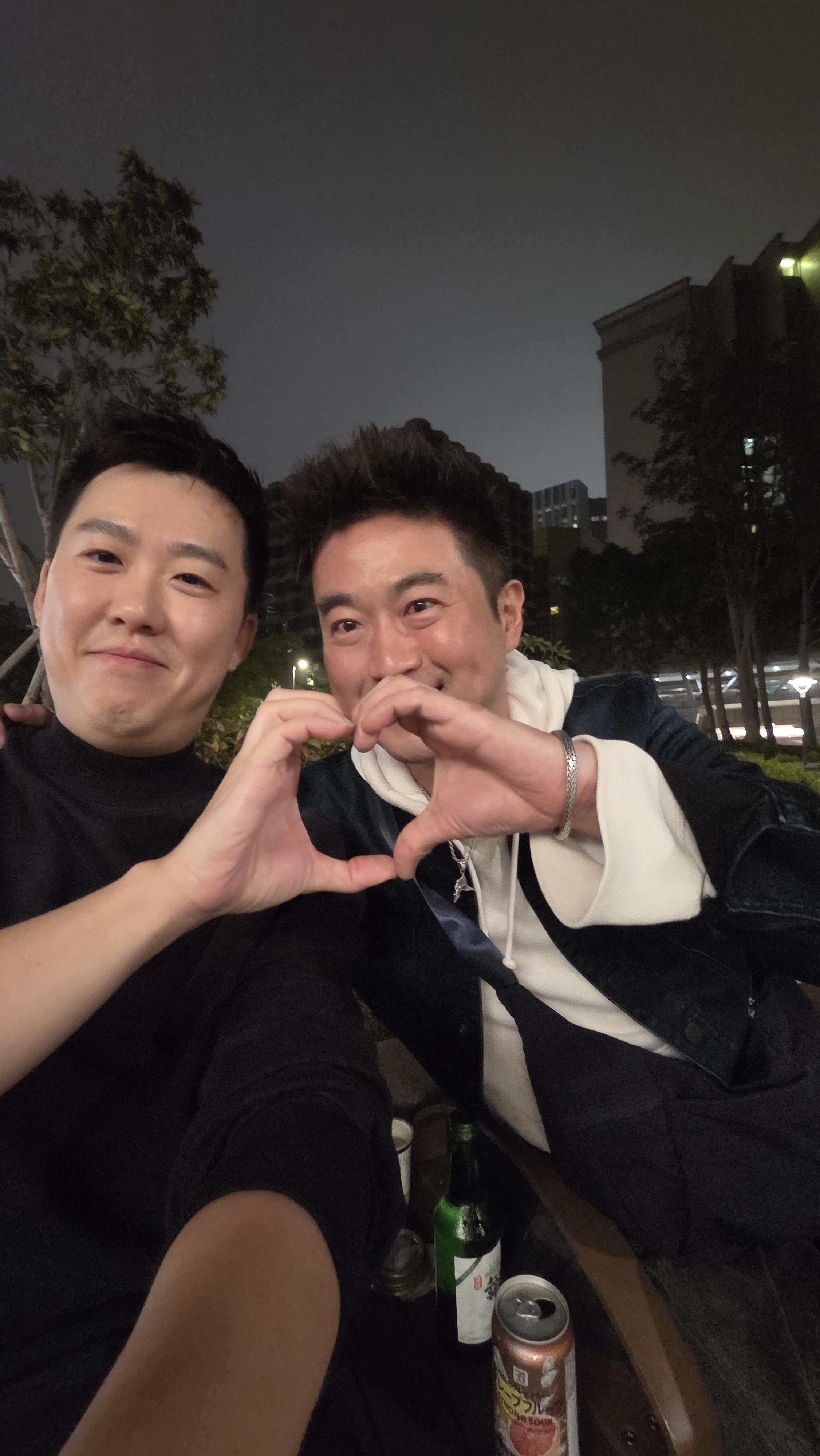 Two men making a heart with their hands