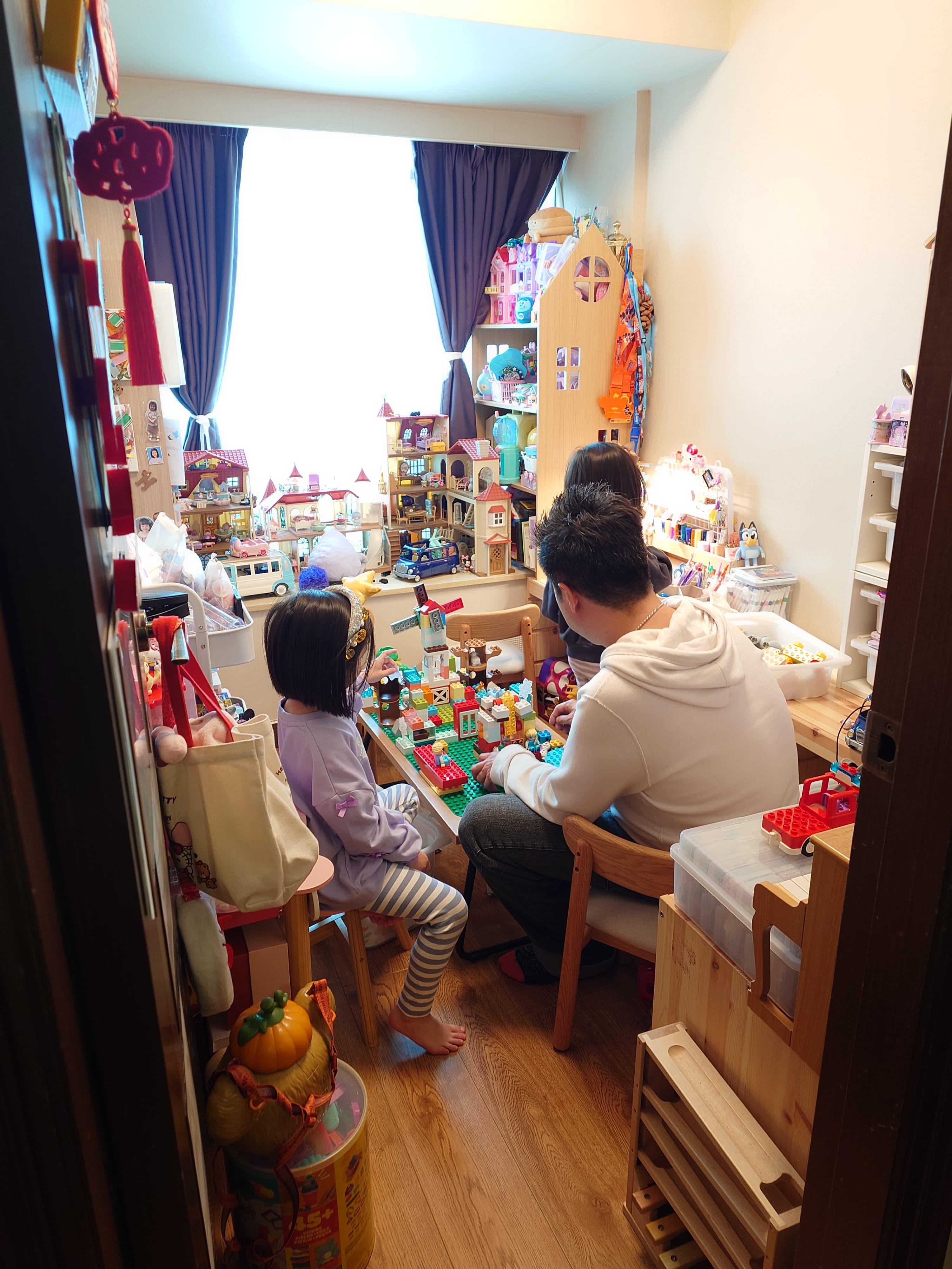 A man and a girl playing with toys
