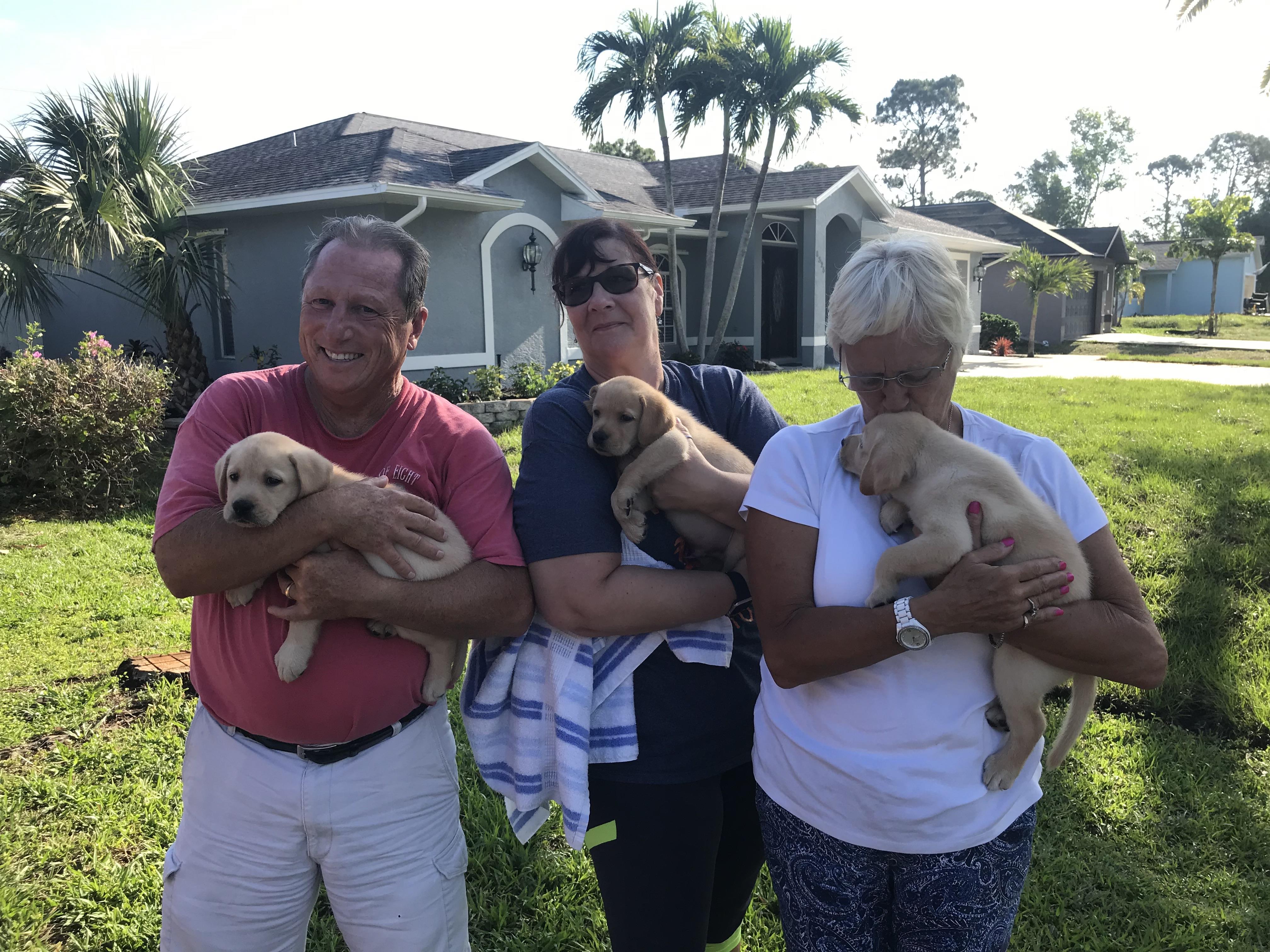 A group of people holding puppies