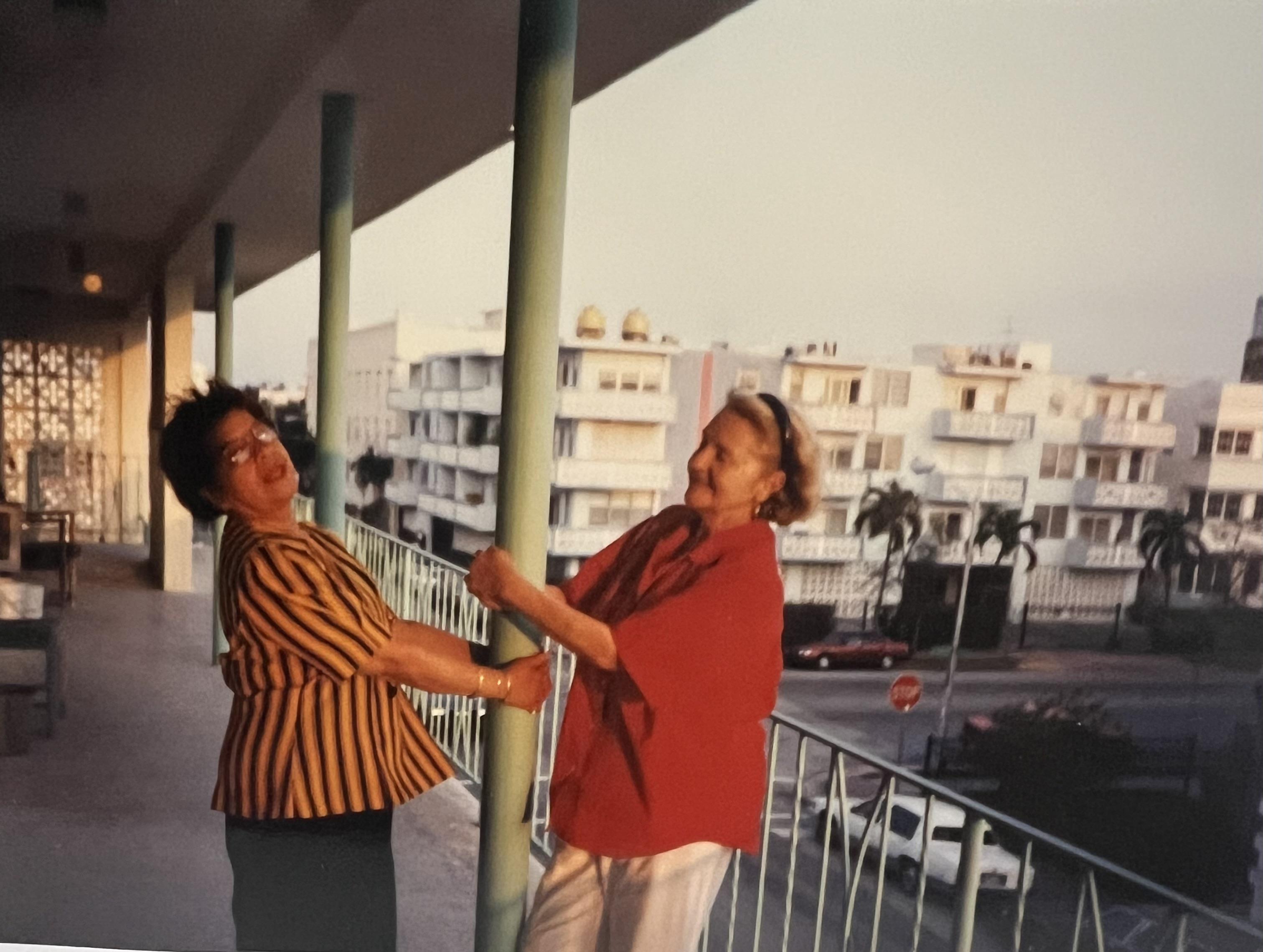 A couple of women standing on a balcony